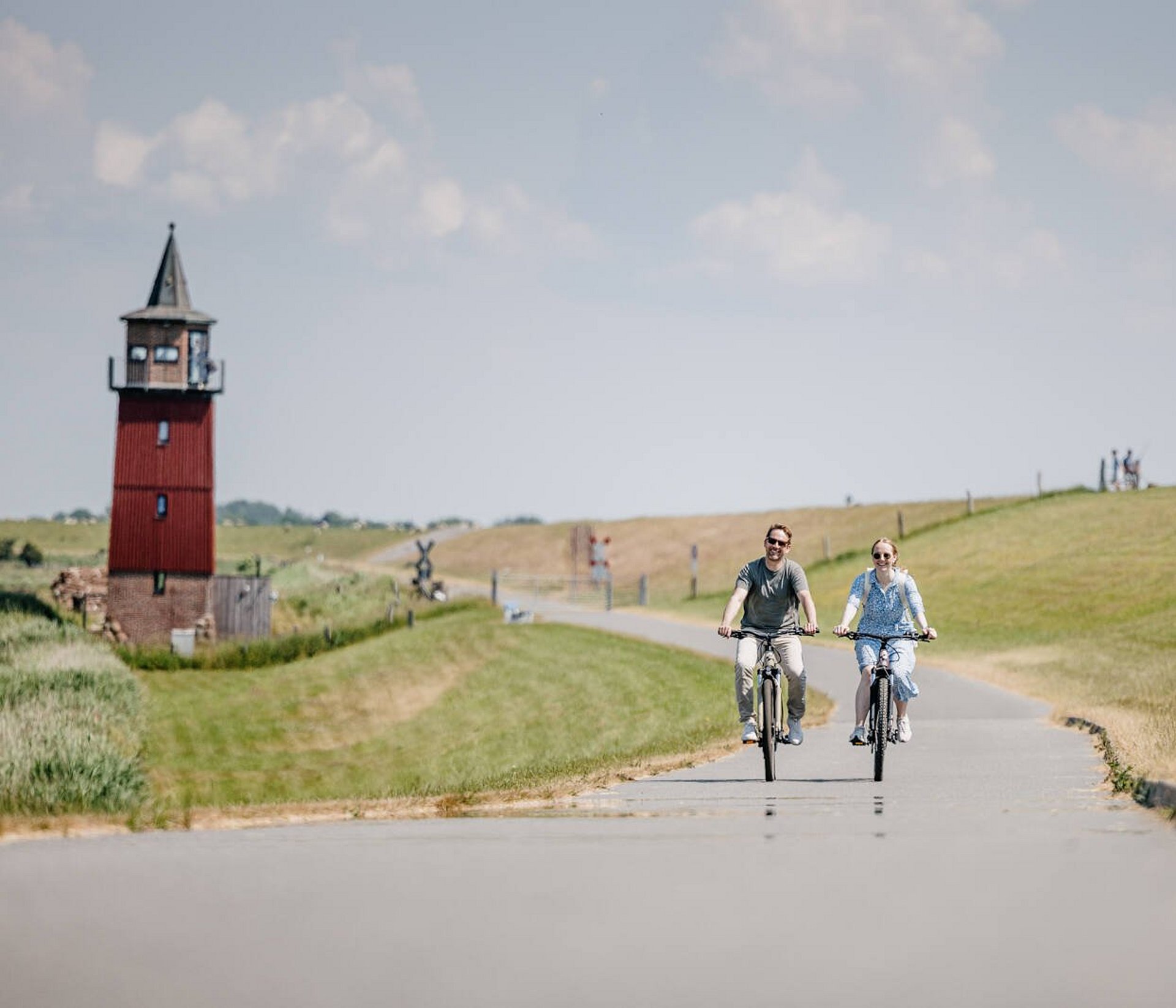 zwei Radfahrer fahren entlang des Dagebüller Leuchtturms