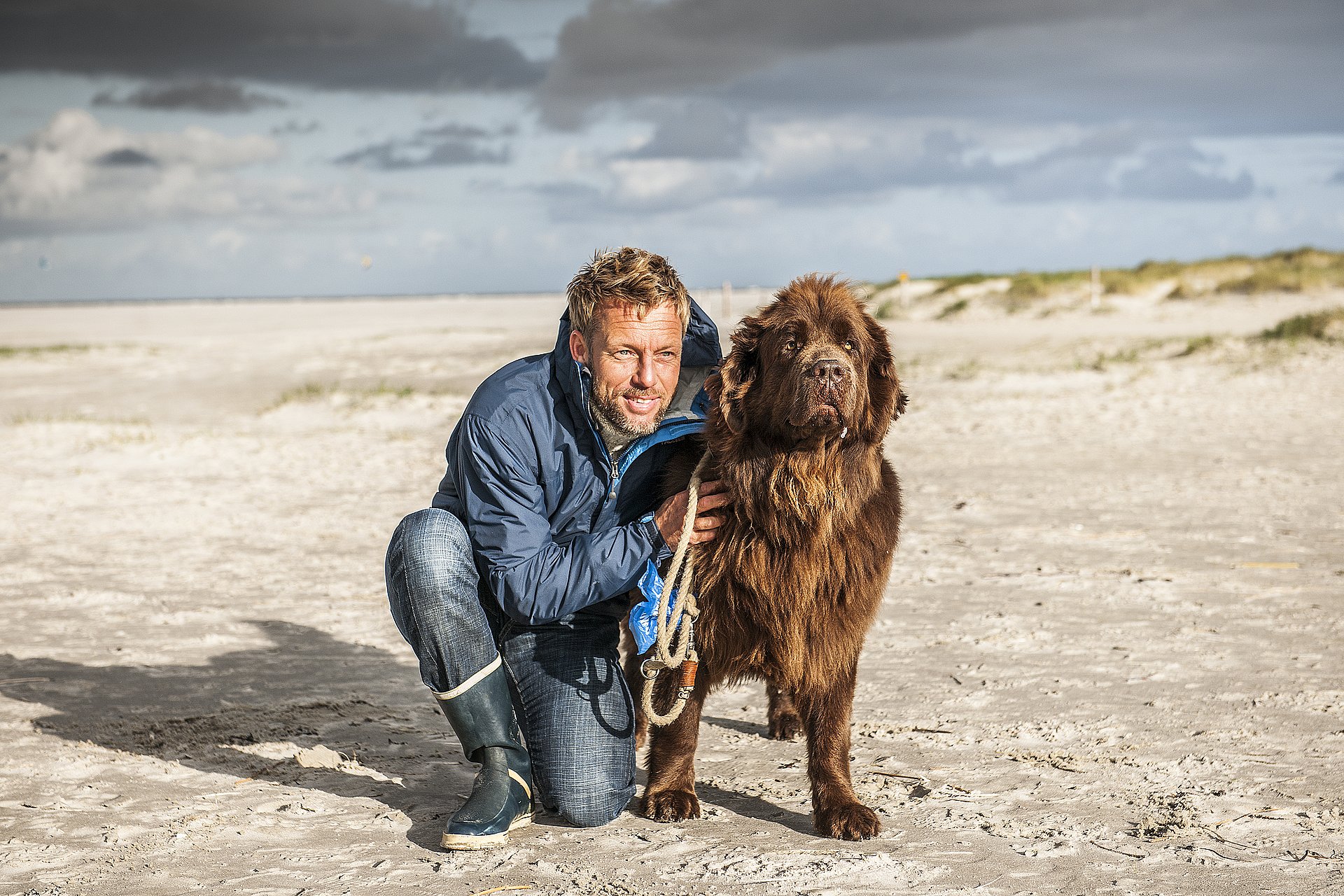 Mann mit Hund am Strand von St. Peter-Ording