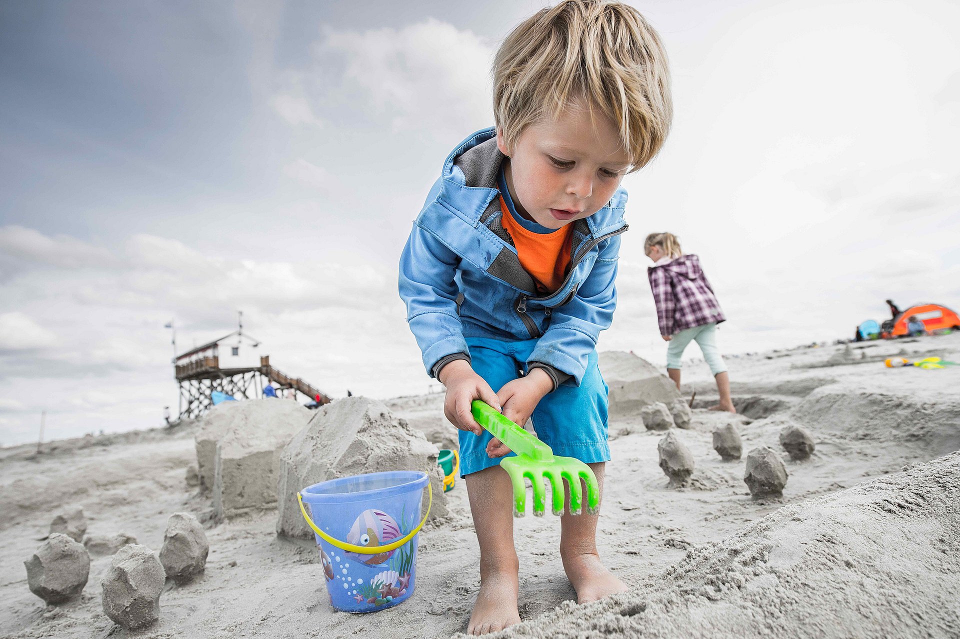 Kind spielt am Strand von SPO im Sand