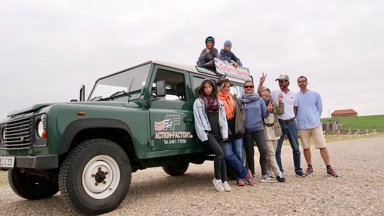 Teilnehmer der Safaritour vor dem Land Rover
