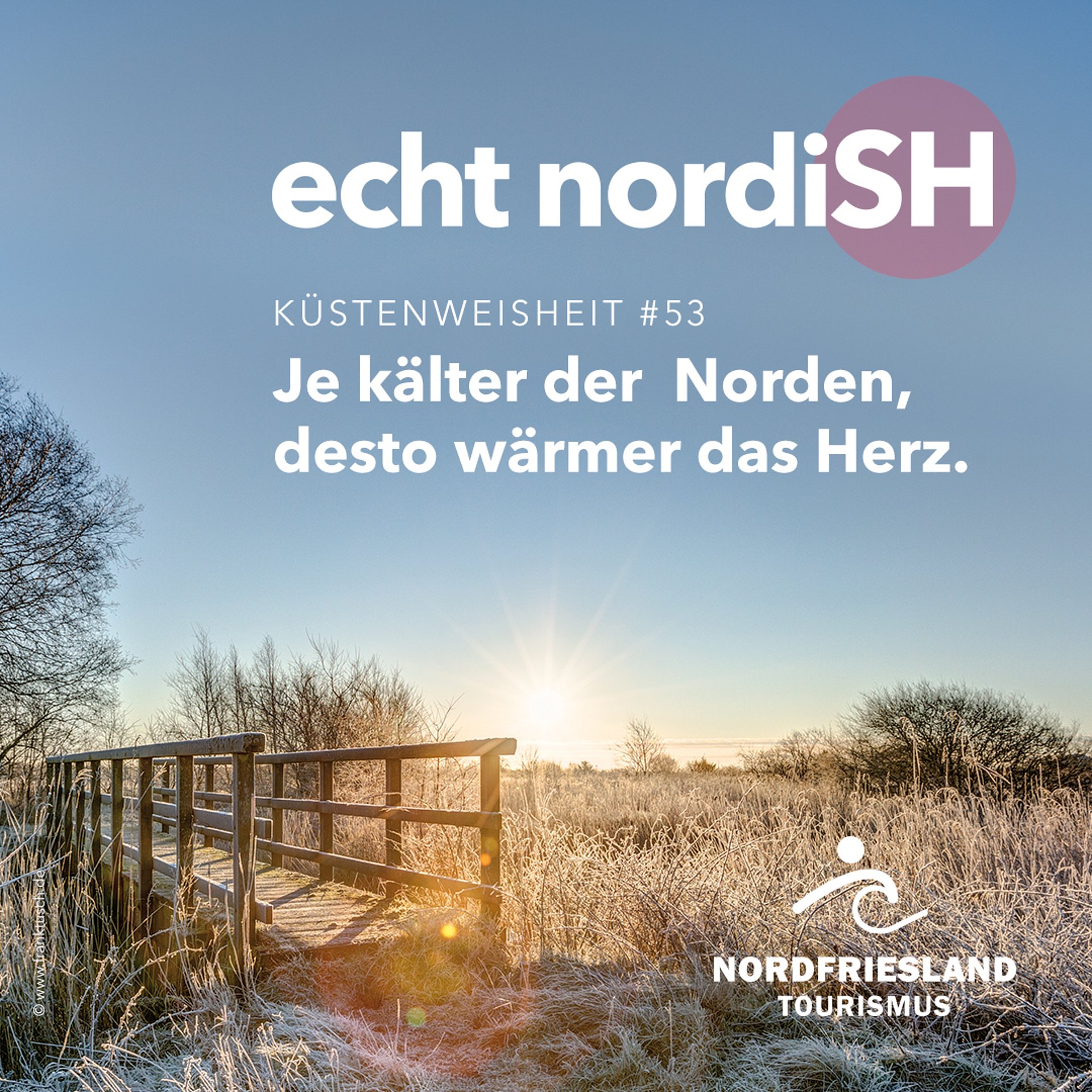 Frost liegt auf der nordfriesischen Landschaft, in der eine kleine Brücke über einen Fluss führt. Auf dem Bild liegt der Schriftzug "Küstenweisheit 53 - Je kälter der Norden, desto wärmer das Herz"