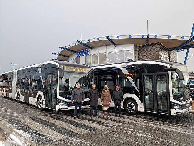Personen stehen vor den neuen Elektrobussen auf Sylt