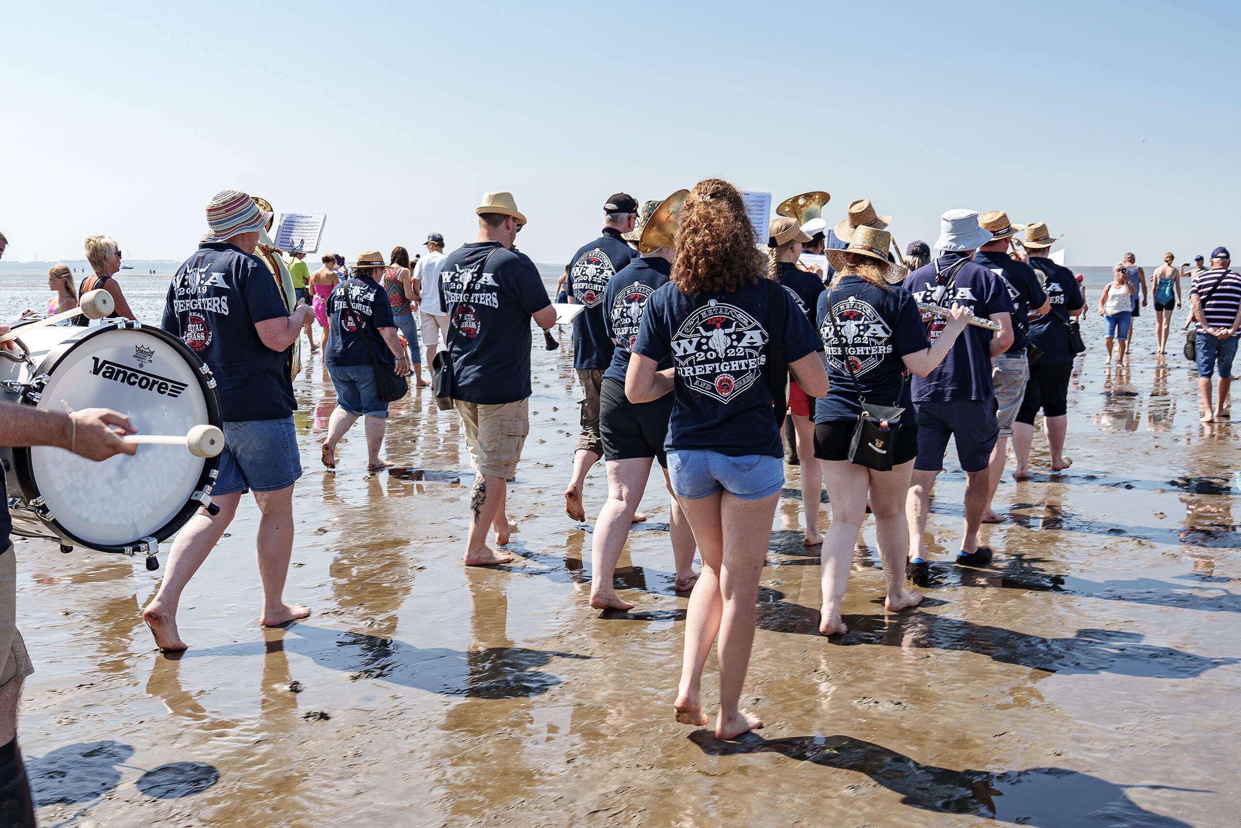 Die Wacken- Firefighters Blaskapelle begleitet eine Gruppe Wattwanderer durchs Wattenmeer.