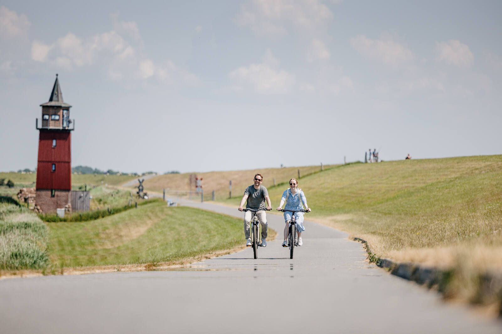 zwei Radfahrer fahren entlang des Dagebüller Leuchtturms
