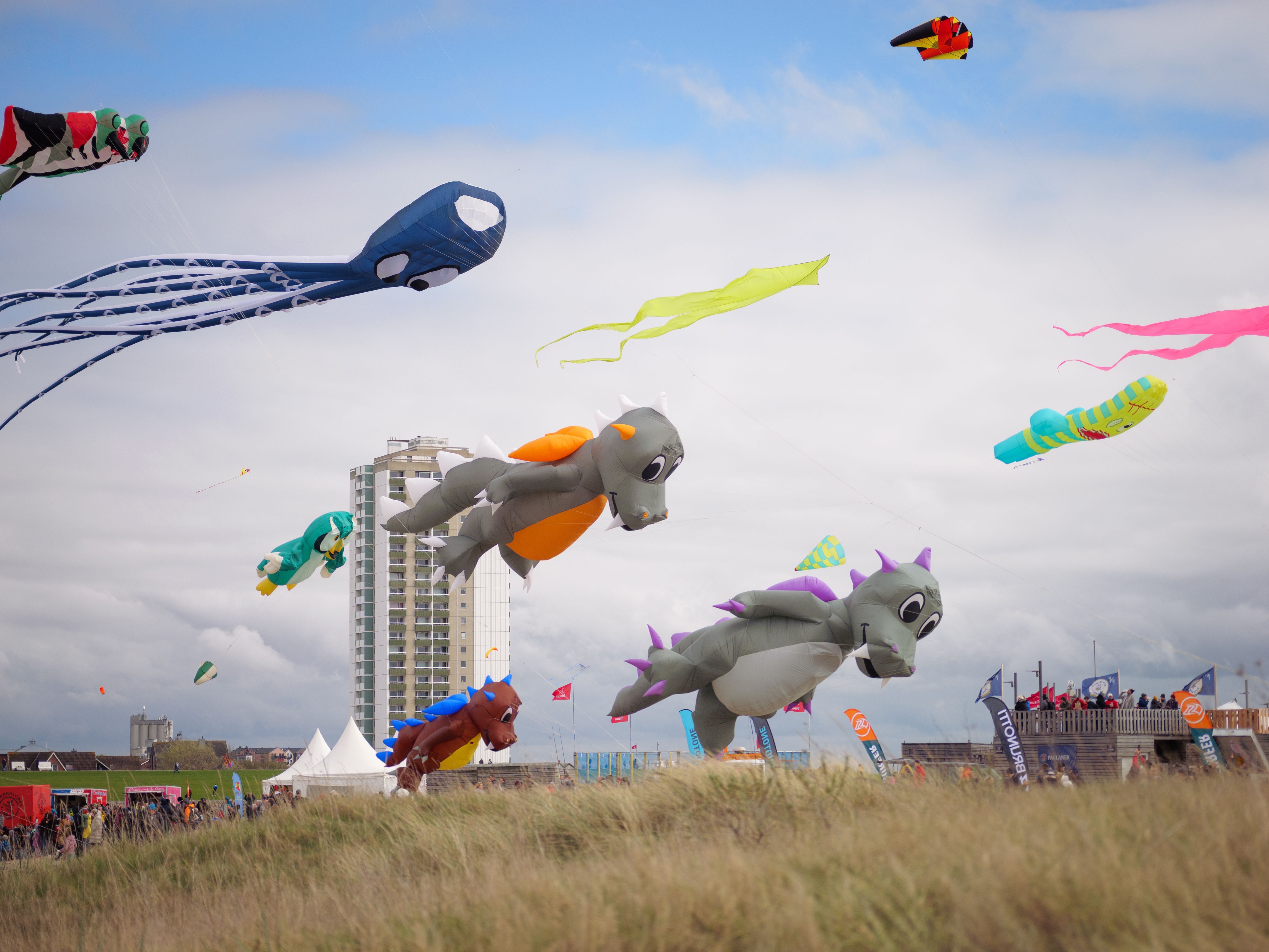 Große und bunte Drachenfiguren segeln bei den Büsumer Drachenflugtagen über dem Deich von Büsum.