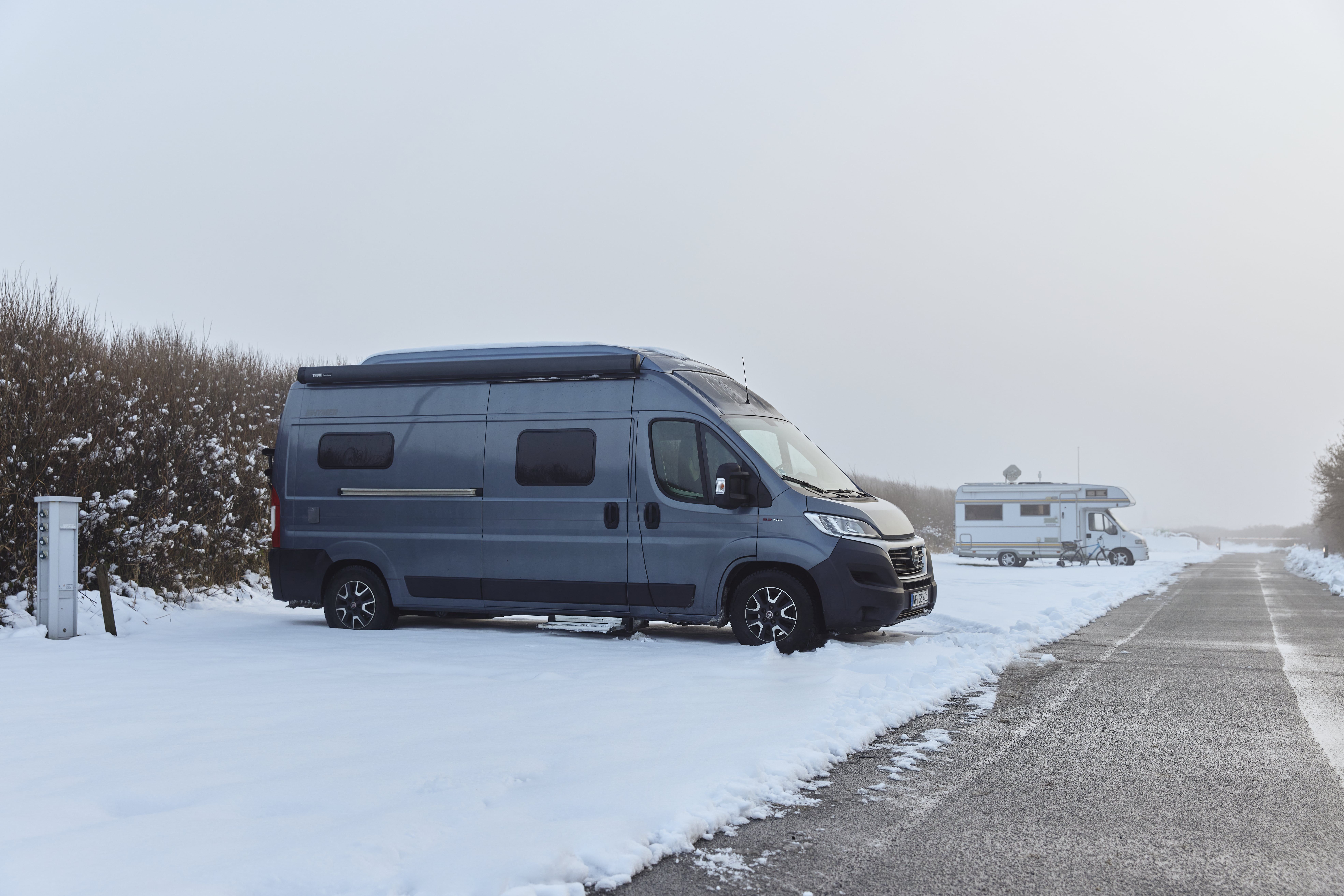 Ein Campervan steht im Schnee auf dem Westerländer Campingplatz