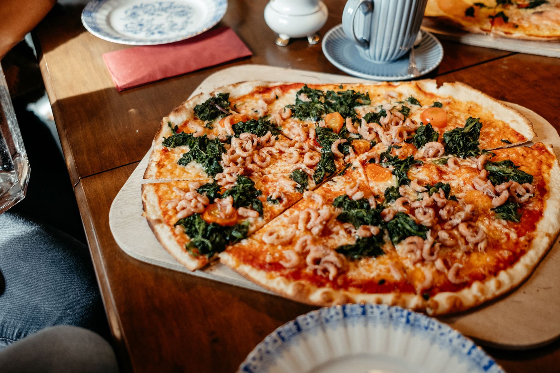 Eine Pizza mit Krabben belegt steht auf einem Tisch