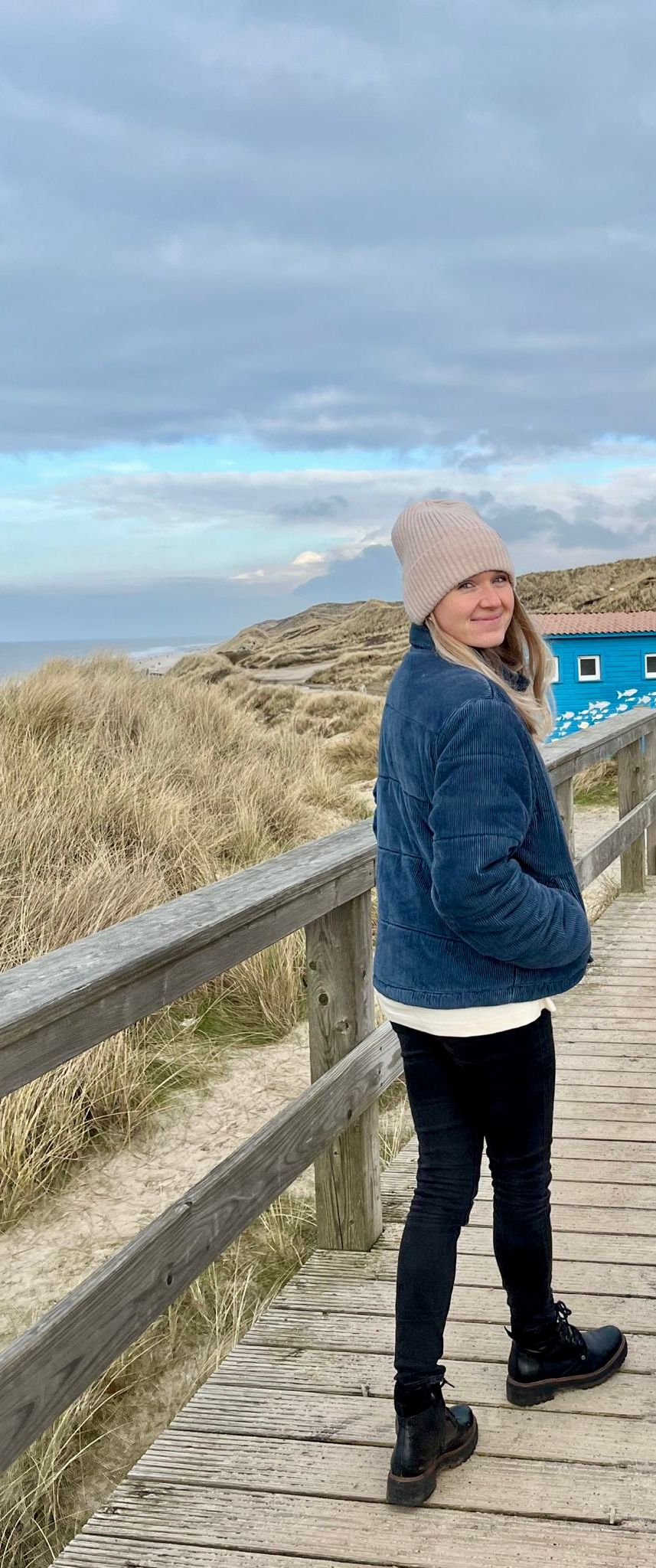 Eine Frau spaziert im Winter an den Sylter Dünen entlang