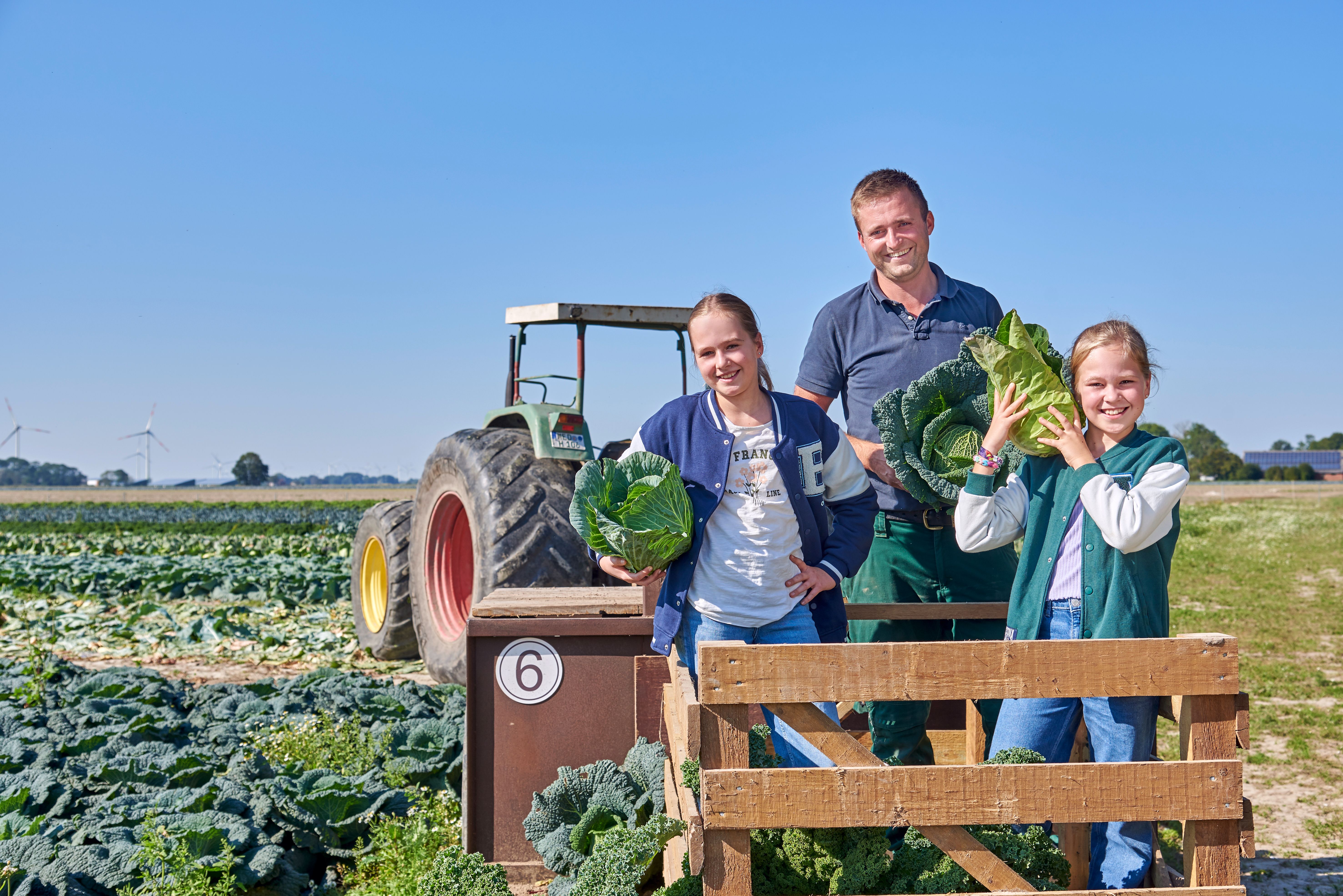 Die Familie des Hof Hinrichs auf ihrem Kohlfeld, bereit zur Ernte