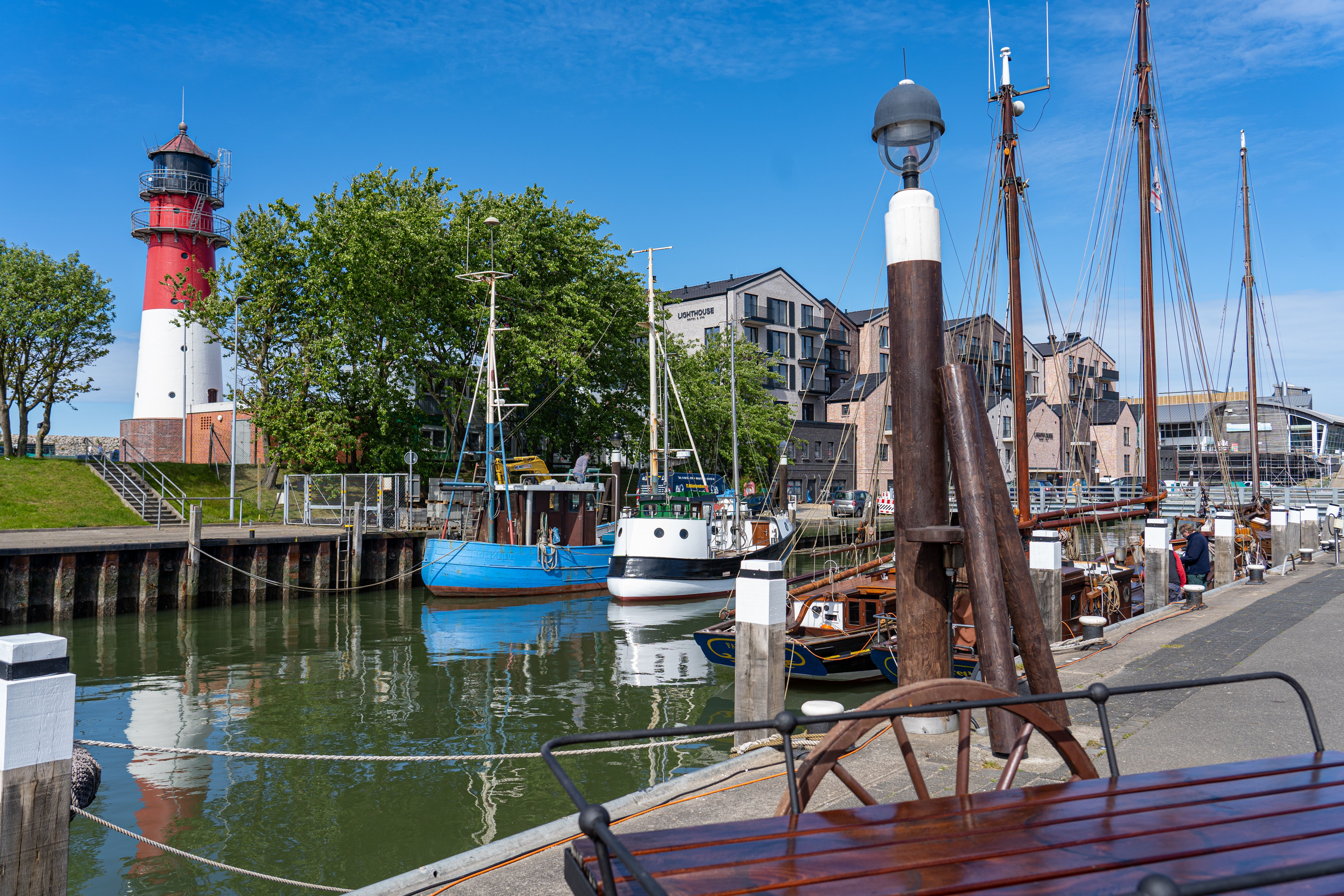 Blick auf den historischen Hafen von Büsum, dahinter ist der Leuchtturm zu sehen