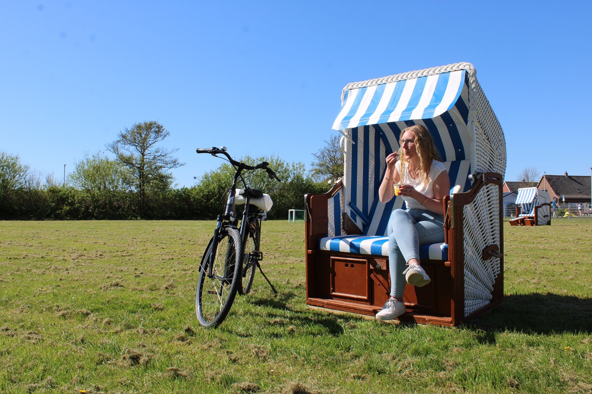 So lässt es ich aushalten! Eine Radfahrerin hat ihr Bike neben einem Strandkorb abgestellt und genießt einen Becher Eis. Foto: Martina Sahm 