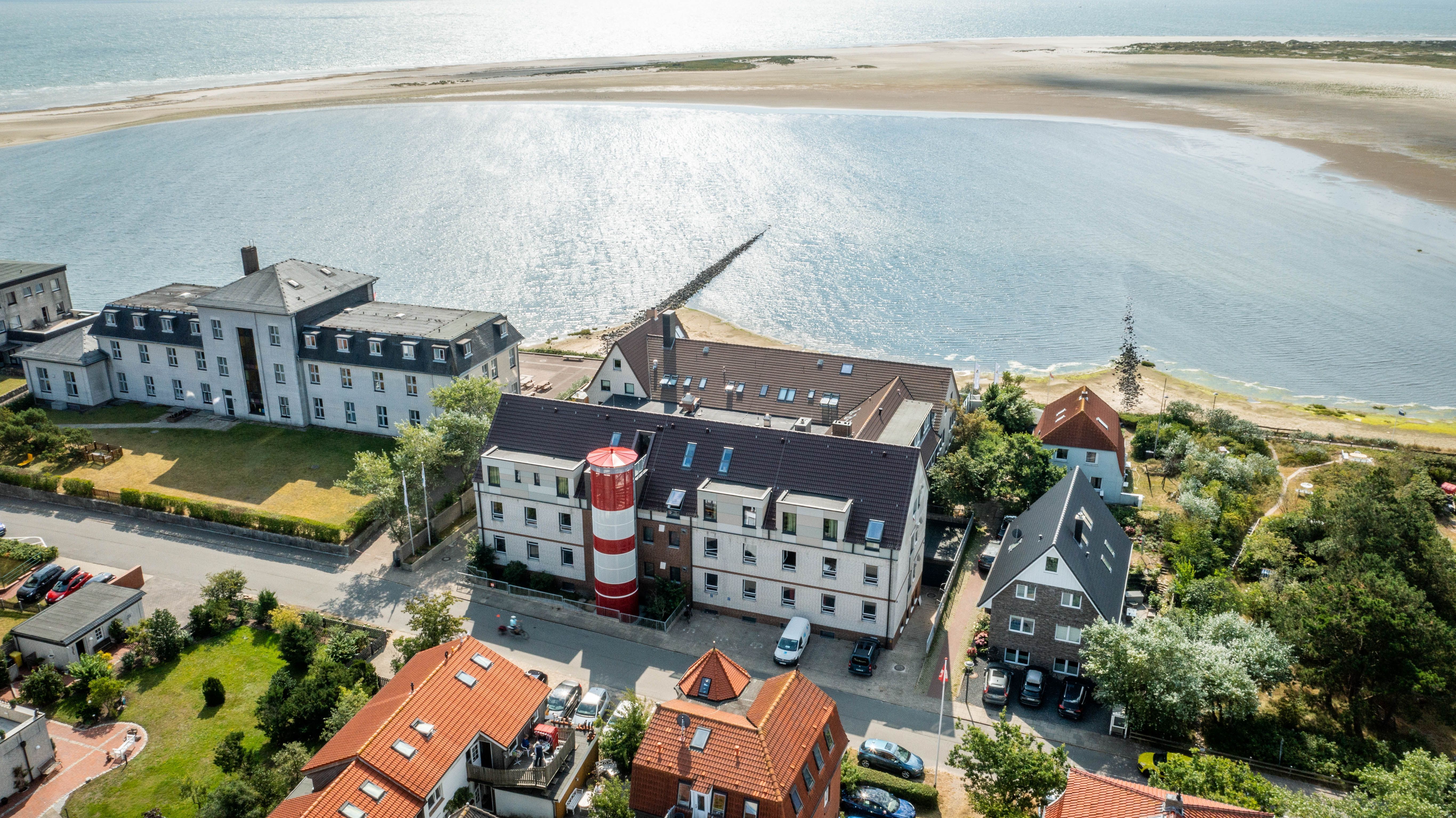 Die Jugendherberge auf Amrum mit ihrem markanten Leuchturm an der Außenfassade aus der Luft aufgenommen. - Foto: DJH-Landesverband Nordmark e.V.