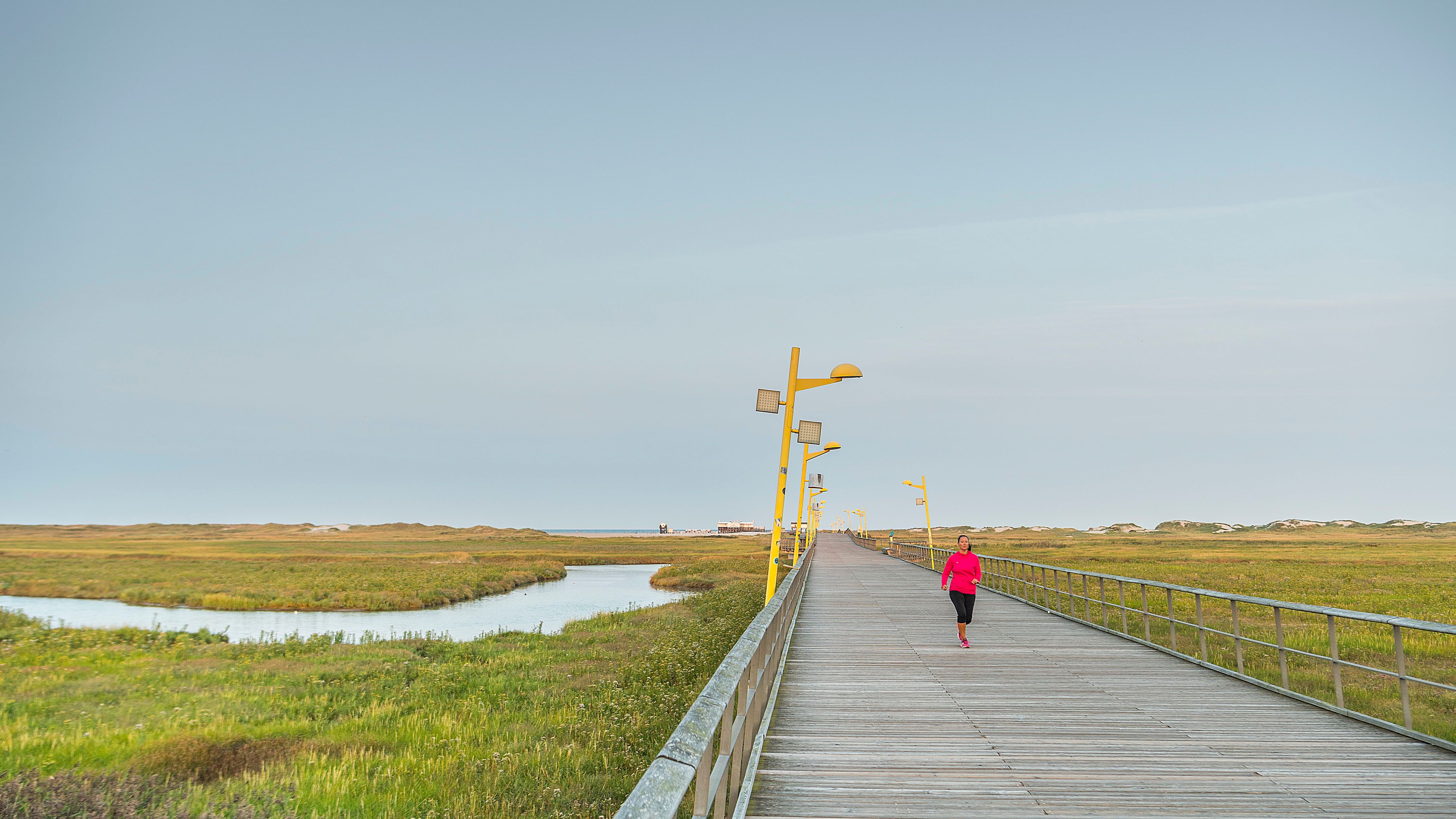 Ein Joggerin läuft auf der Seebrücke von SPO Richtung Promenade.