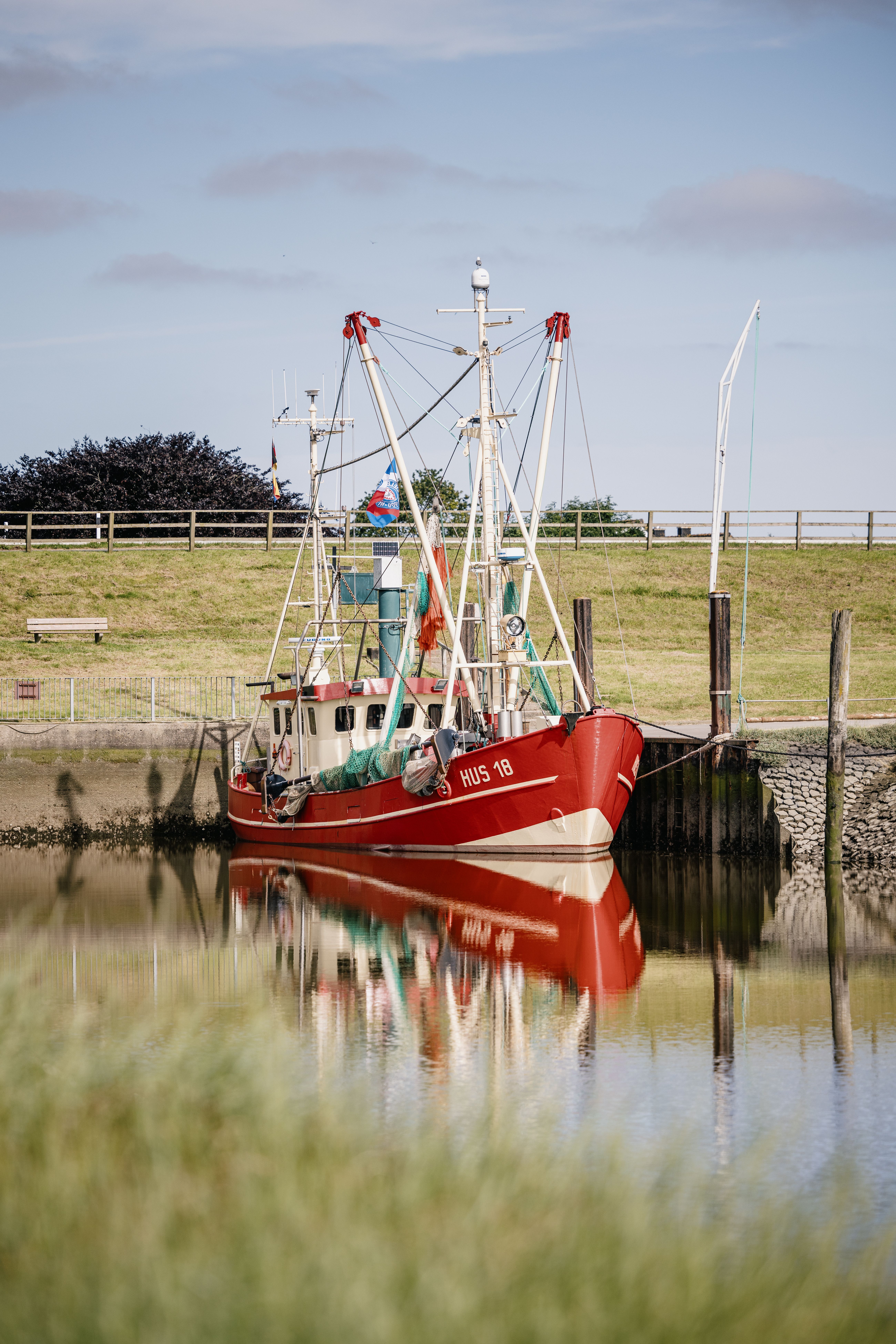 Ein roterweißer Fischkutter liegt im Süderhafen der Halbinsel Nordstrand. Foto: Nordseeküste Nordfriesland | Markus Rohrbacher