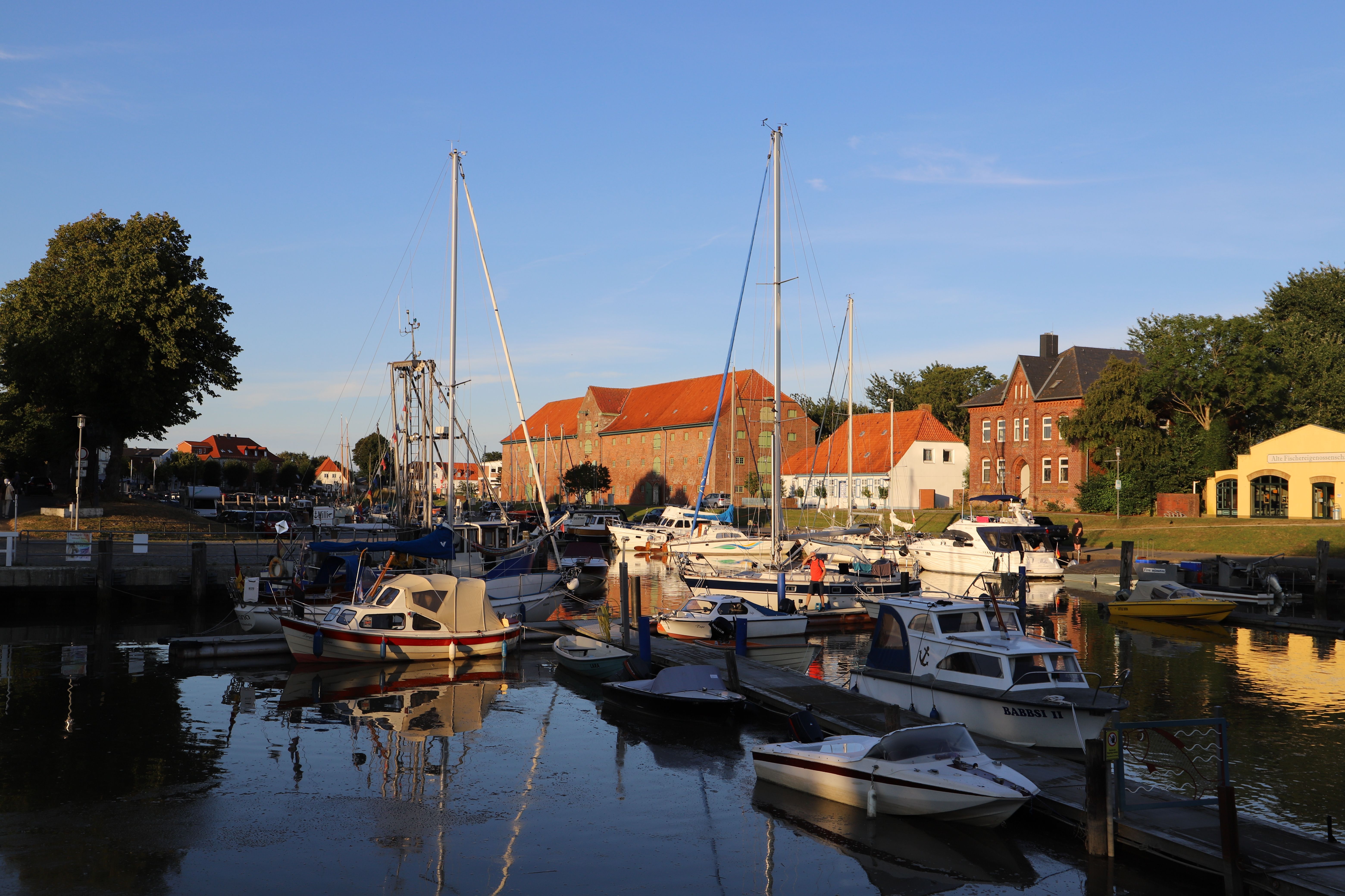 Der Historische Hafen in Tönning mit Sportsegelschiffen, dem Packhaus im Hintergrund im Abendlicht der Sonne. Foto: TuF Tönning