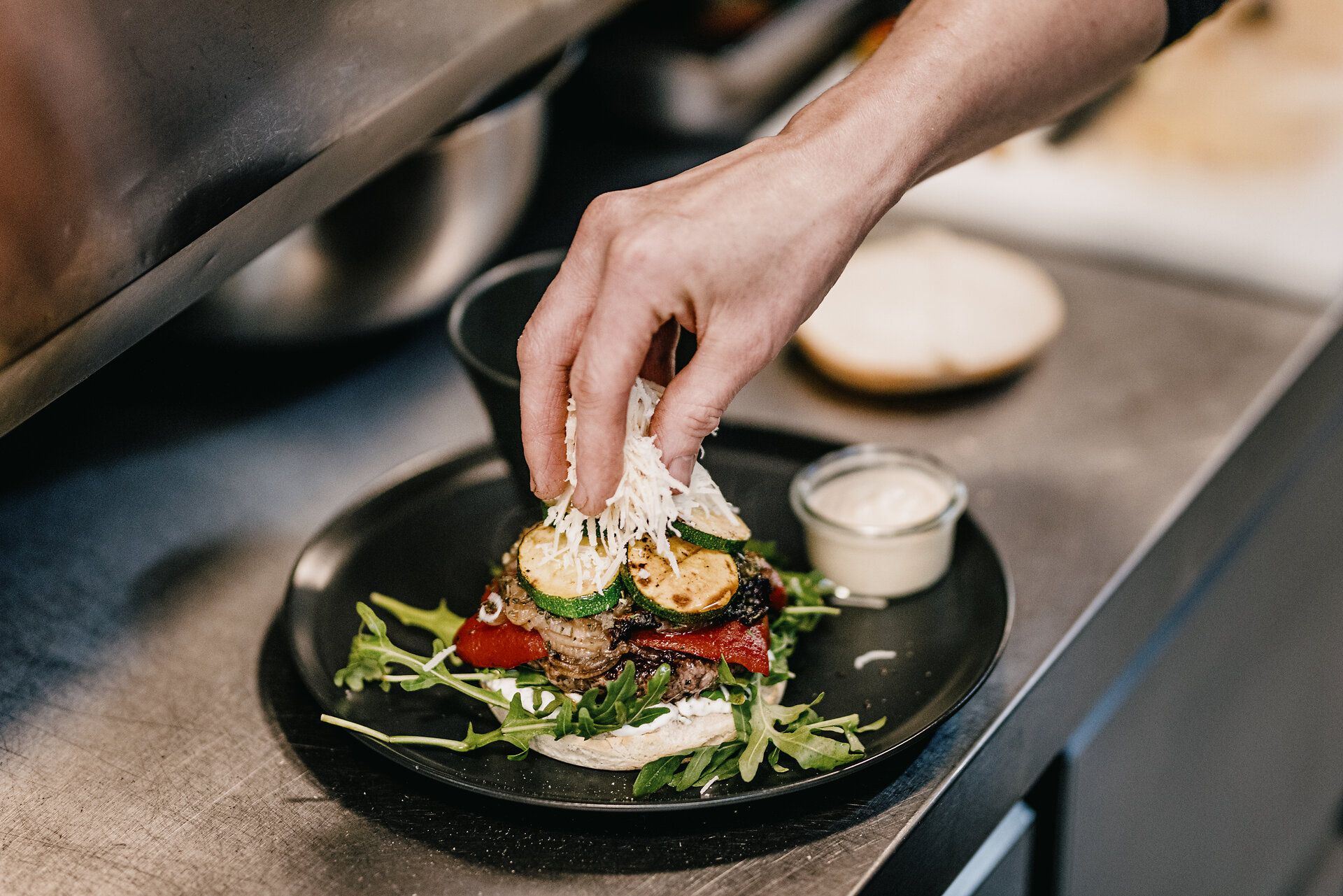 Ein Sterne Burger bekommt sein letztes Finish bevor die obere Hälfte des "Brötchens" aufgelegt wird