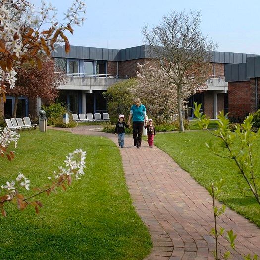 Mutter mit Kindern im Garten des Ev. Kurzentrum GODE TIED in Büsum an der Nordsee