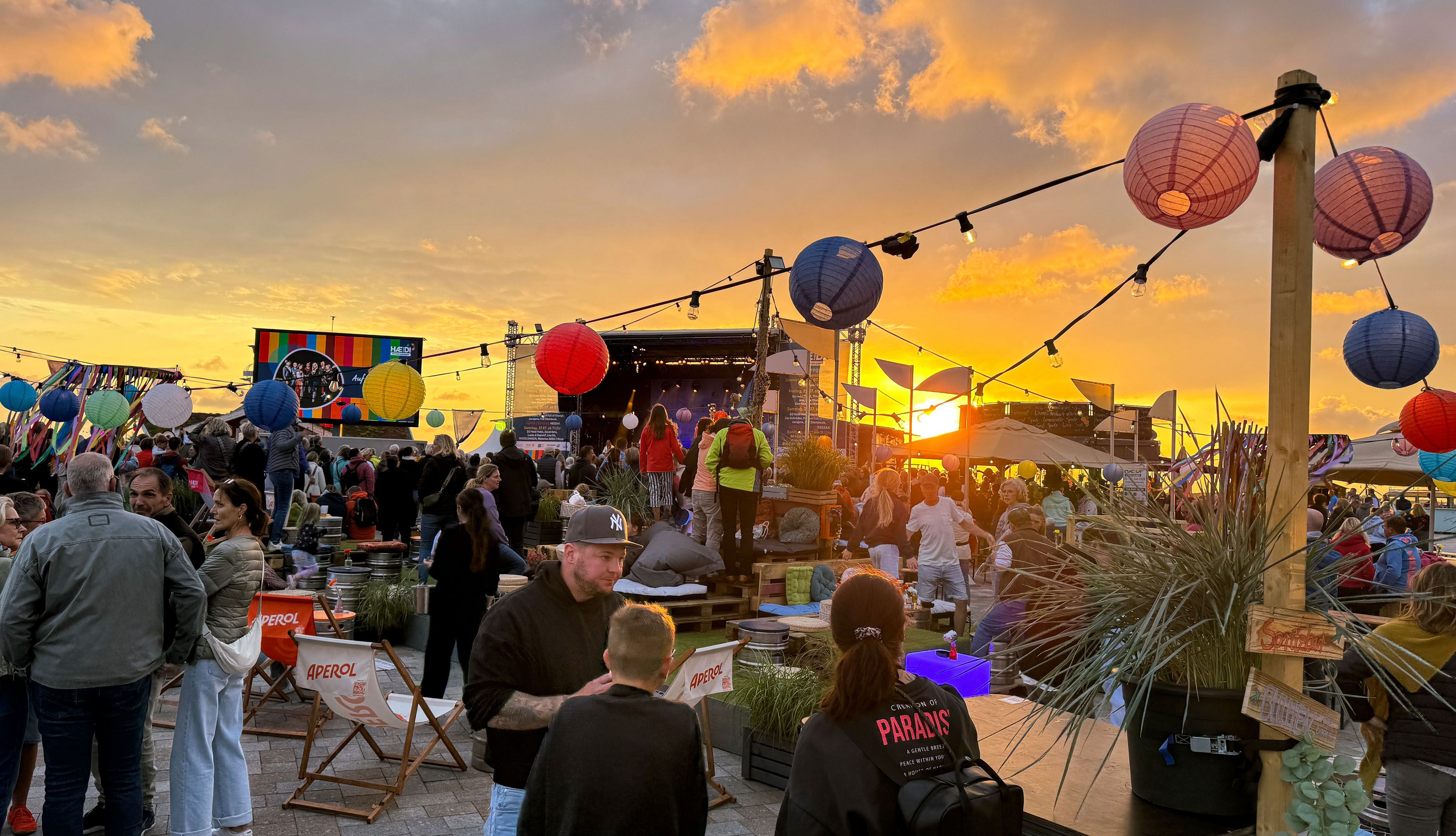 Blick auf das Festivalgelände mit Bühne bei Sonnenuntergang