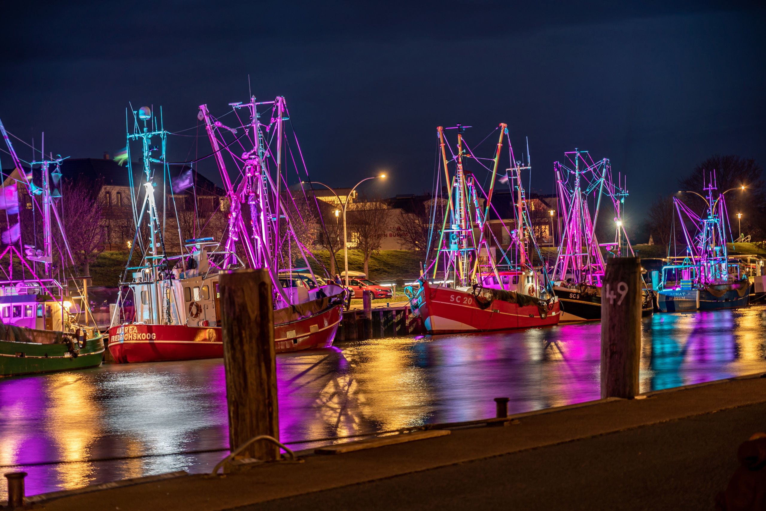 Festlich beleuchtete Kutter im Hafen von Büsum bei Nacht.