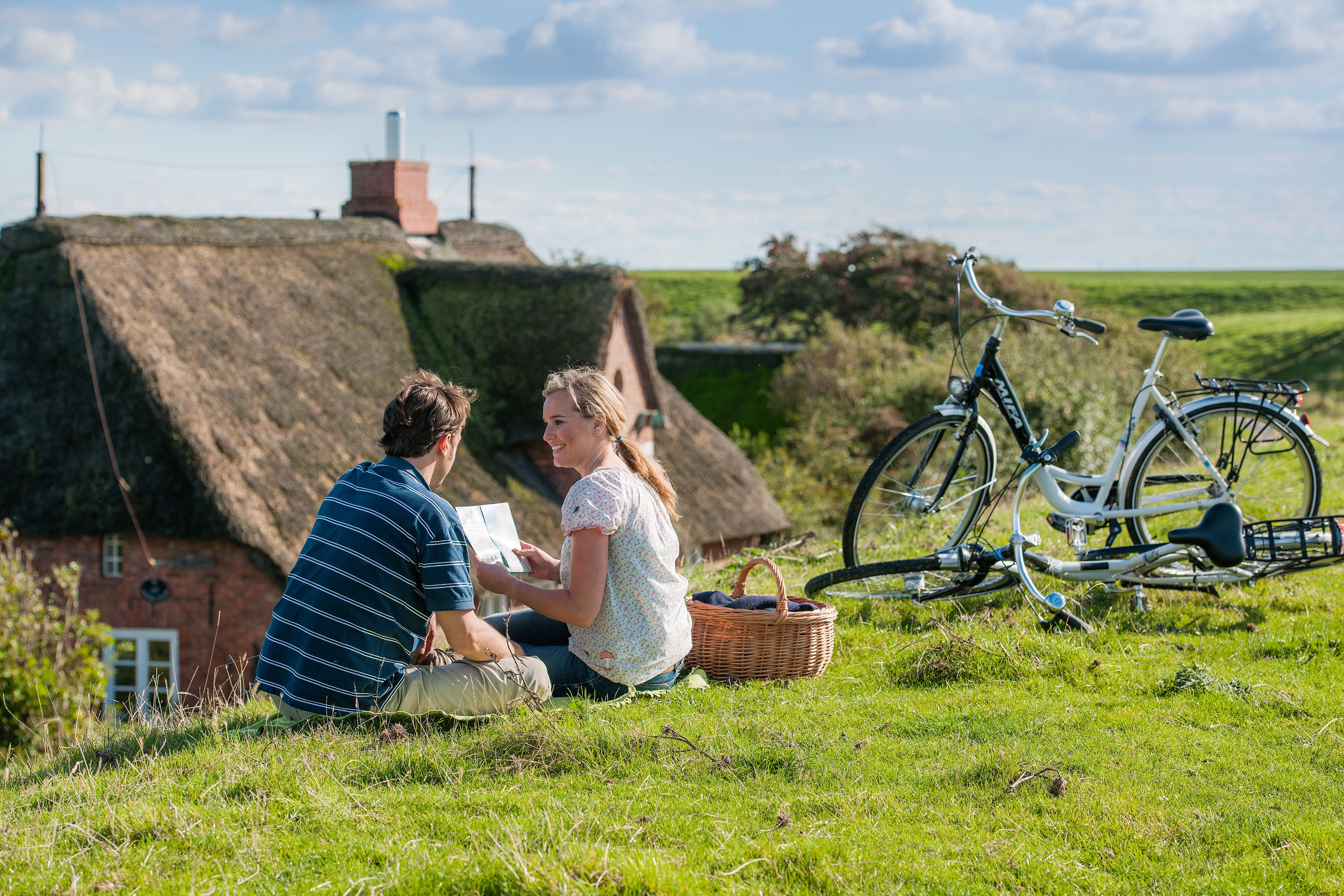 Ein Radlerpaar macht Pause auf dem Deich in Ockholm