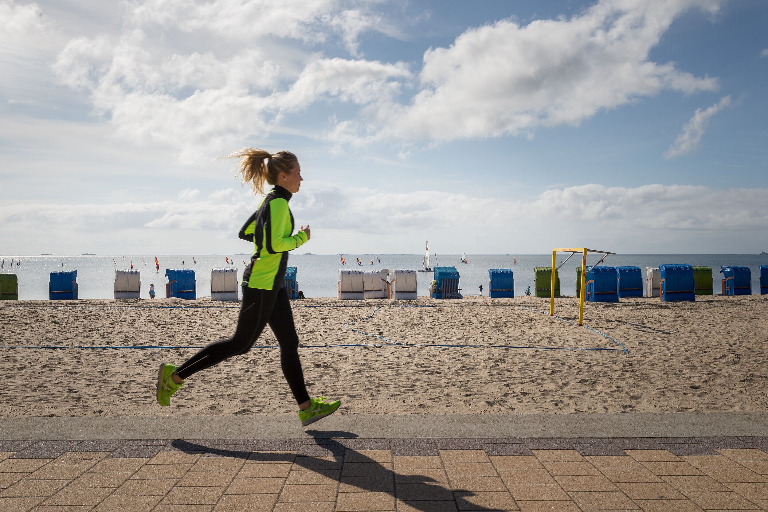 Eine Frau joggt entlang des Föhrer Strandes