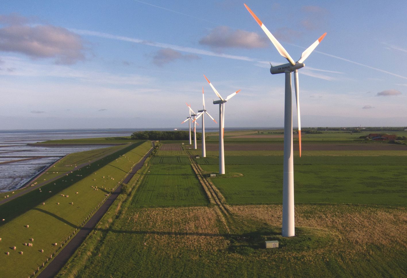 Windräder am Deich auf der Insel Pellworm.