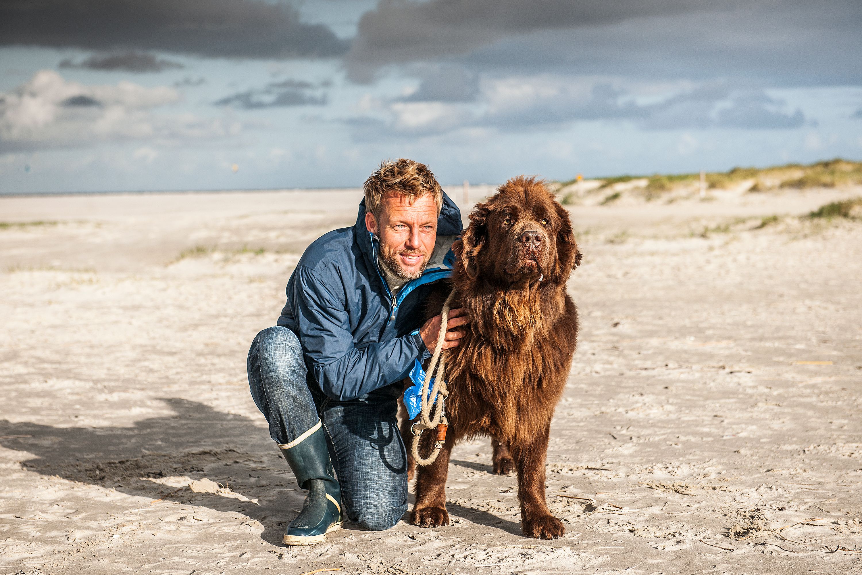 Hund und Herrchen genießen einen sonnigen Tag am Hundestrand an der Nordsee.