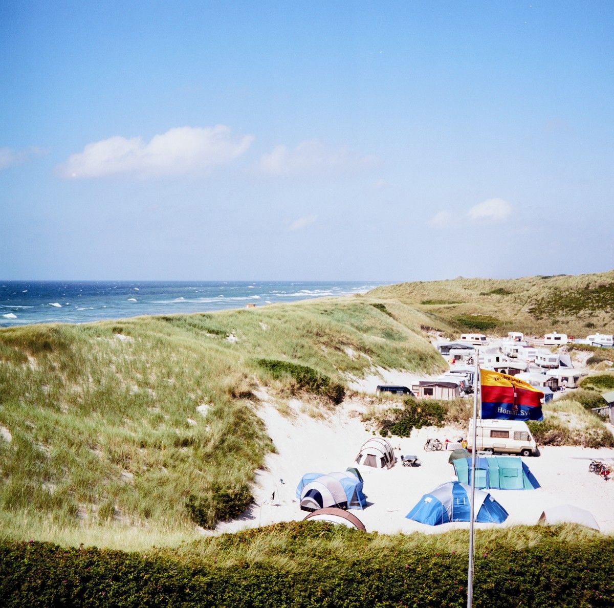 Blick über den Hörnumer Campingplatz im Sand hinter den Dünen mit vielen Zelten