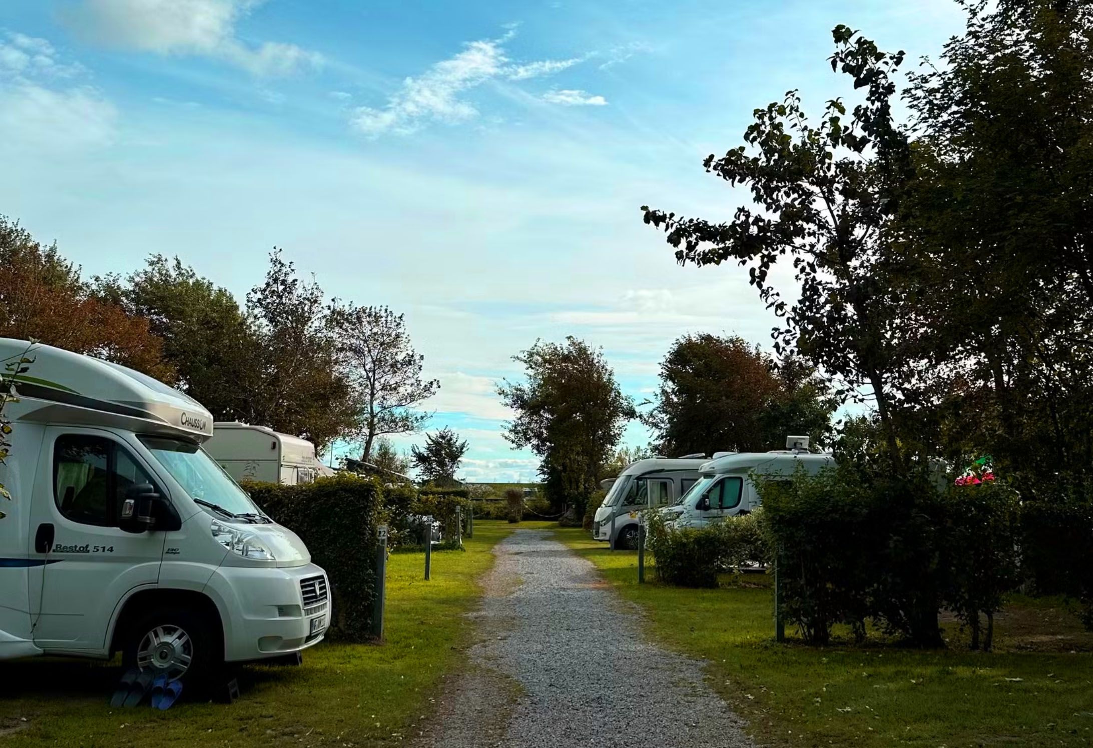 Mehrere Wohnmobile und Wohnwagens stehen auf dem Campingplatz