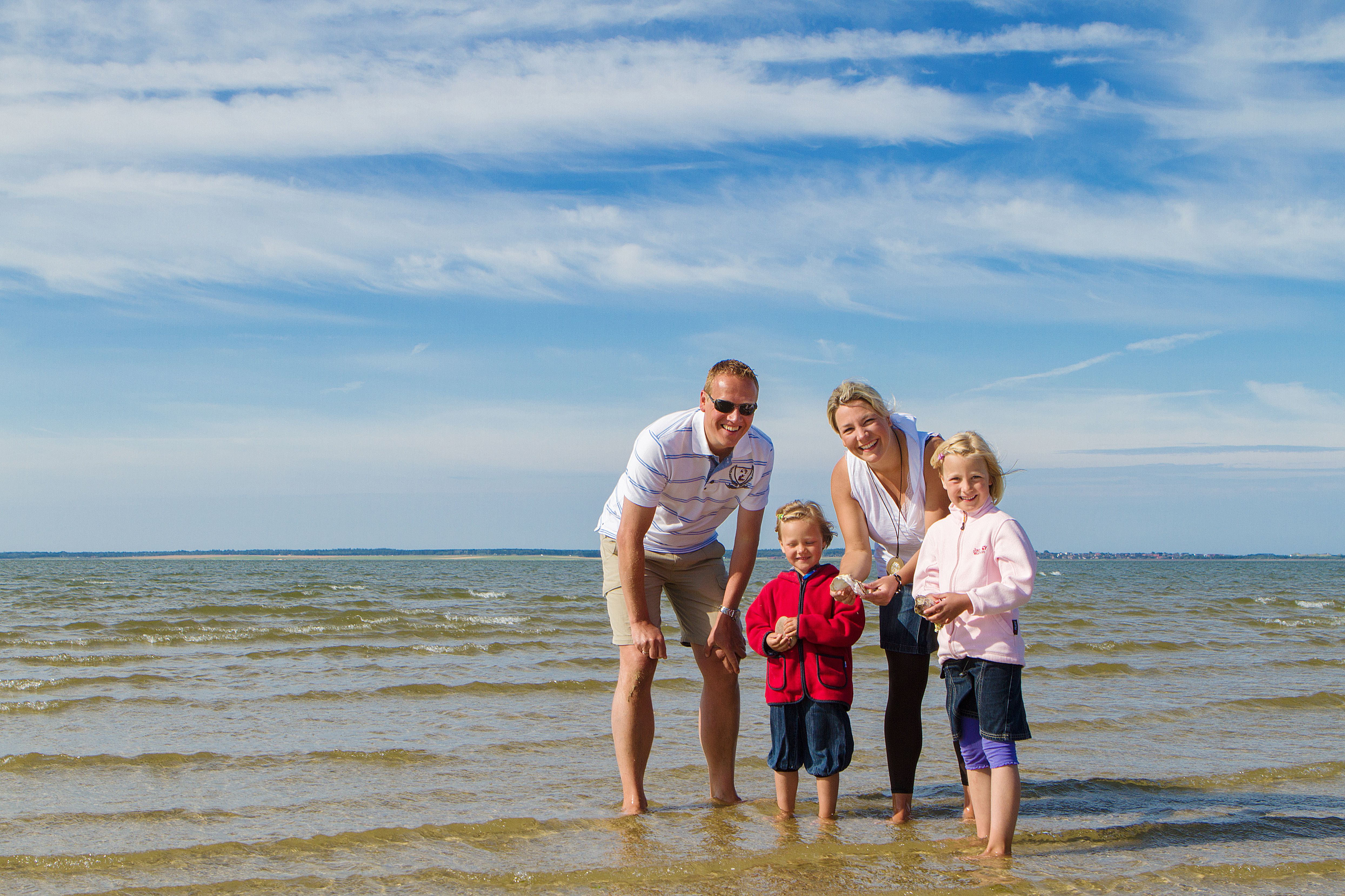 Eine Familie steht am Strand von Föhr im Wasser