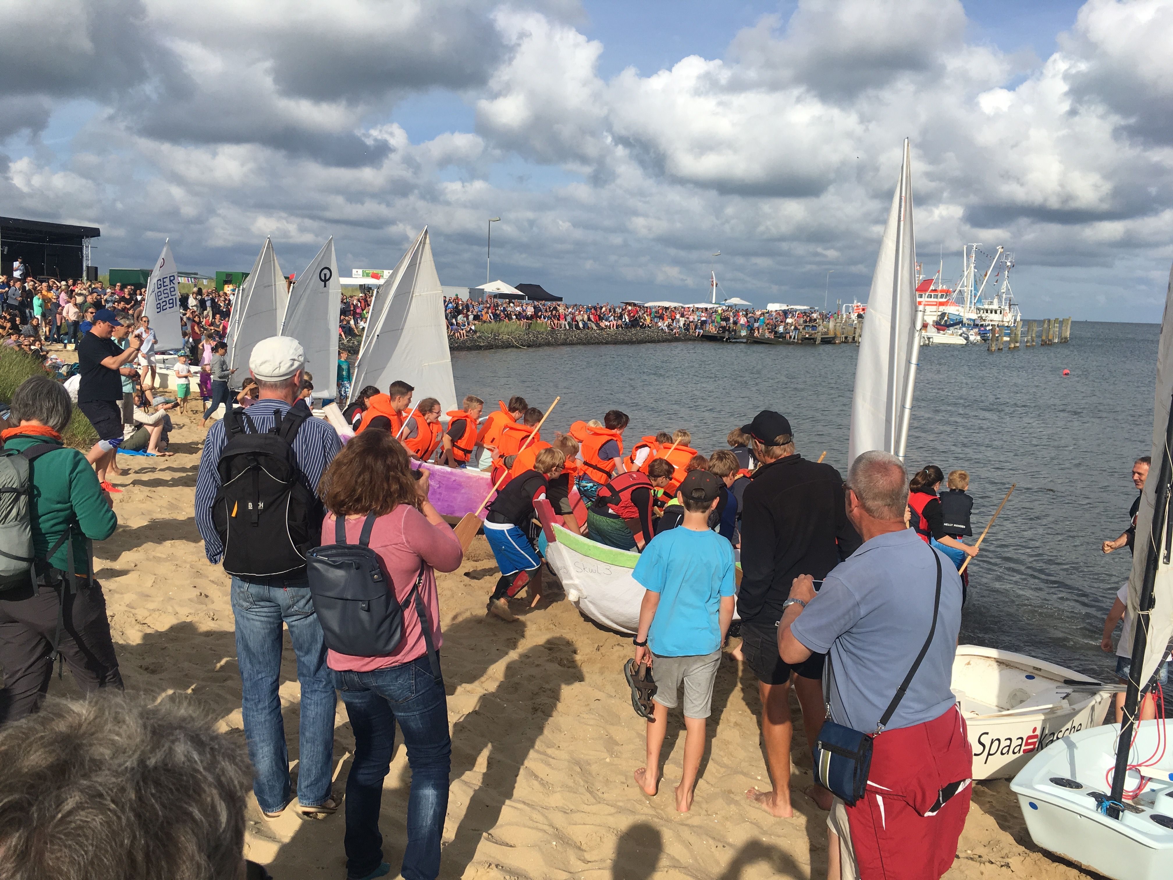 Besucher stehen am Hafen und schauen den jungen Seefahrern zu, wie sie ihre Boote klarmachen