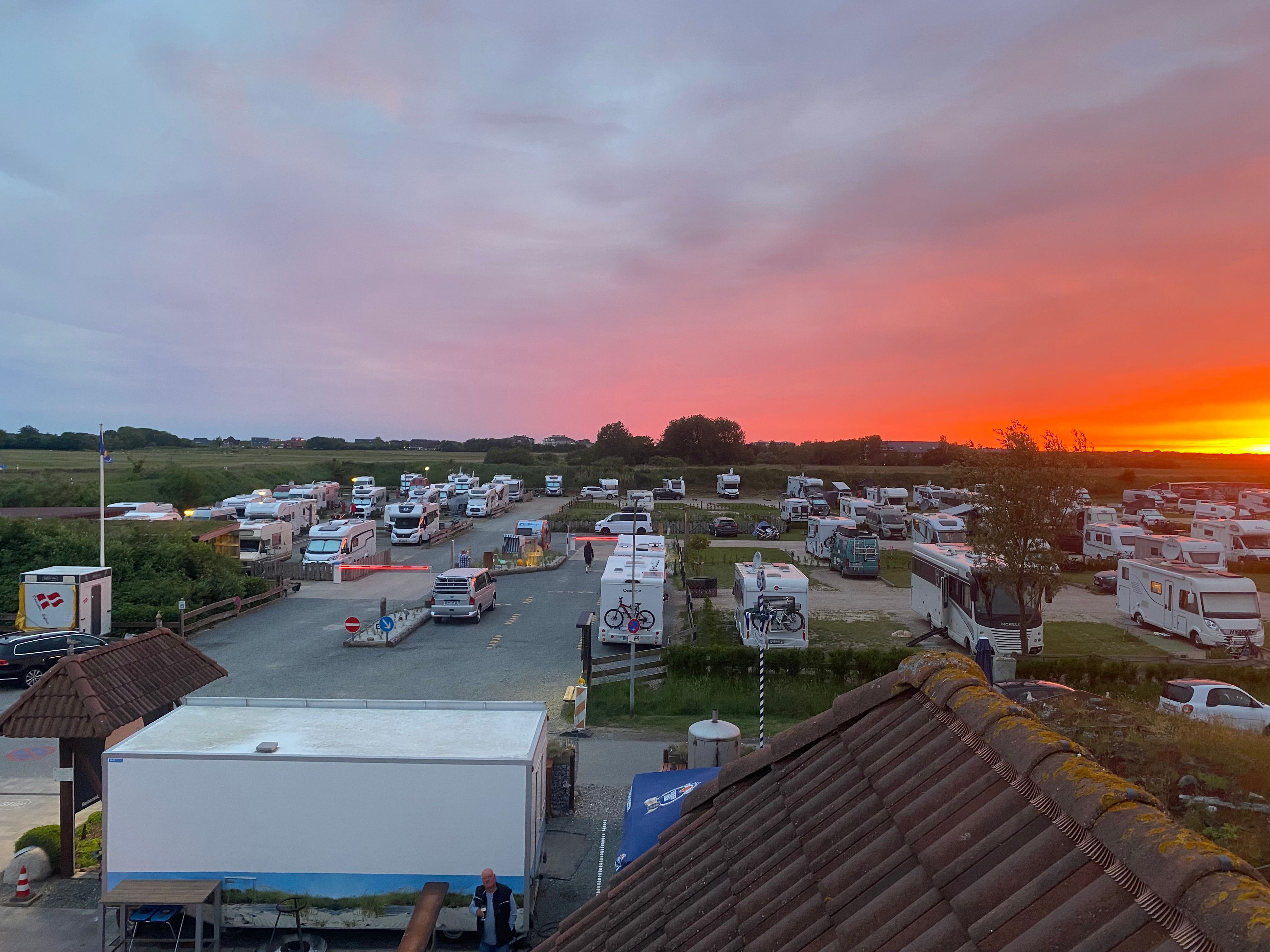 Blick über den Campingplatz SPO, im Hintergrund färbt sich der Himmel danke des Sonnenuntergangs rötlich