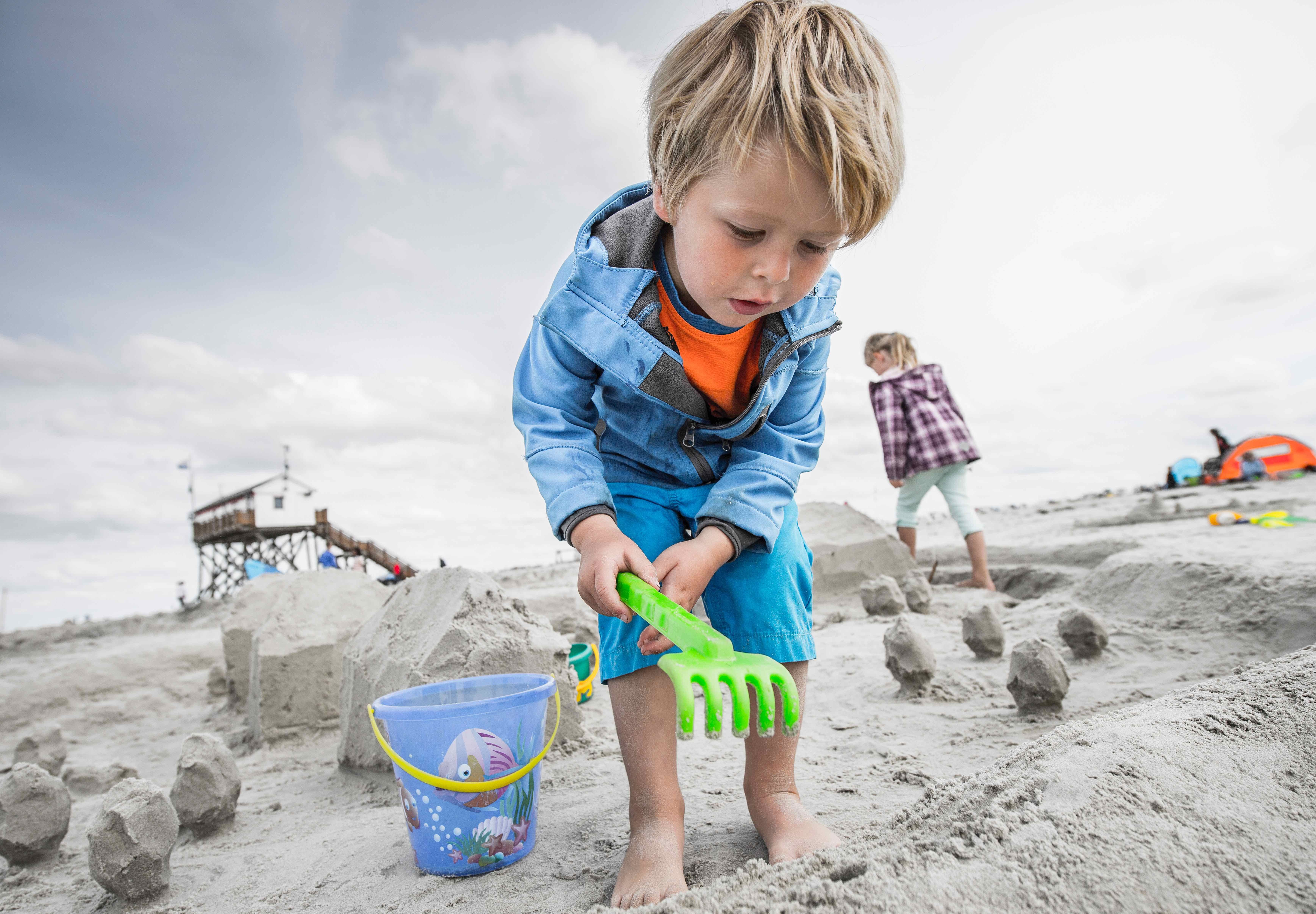 Kind spielt am Strand von SPO im Sand