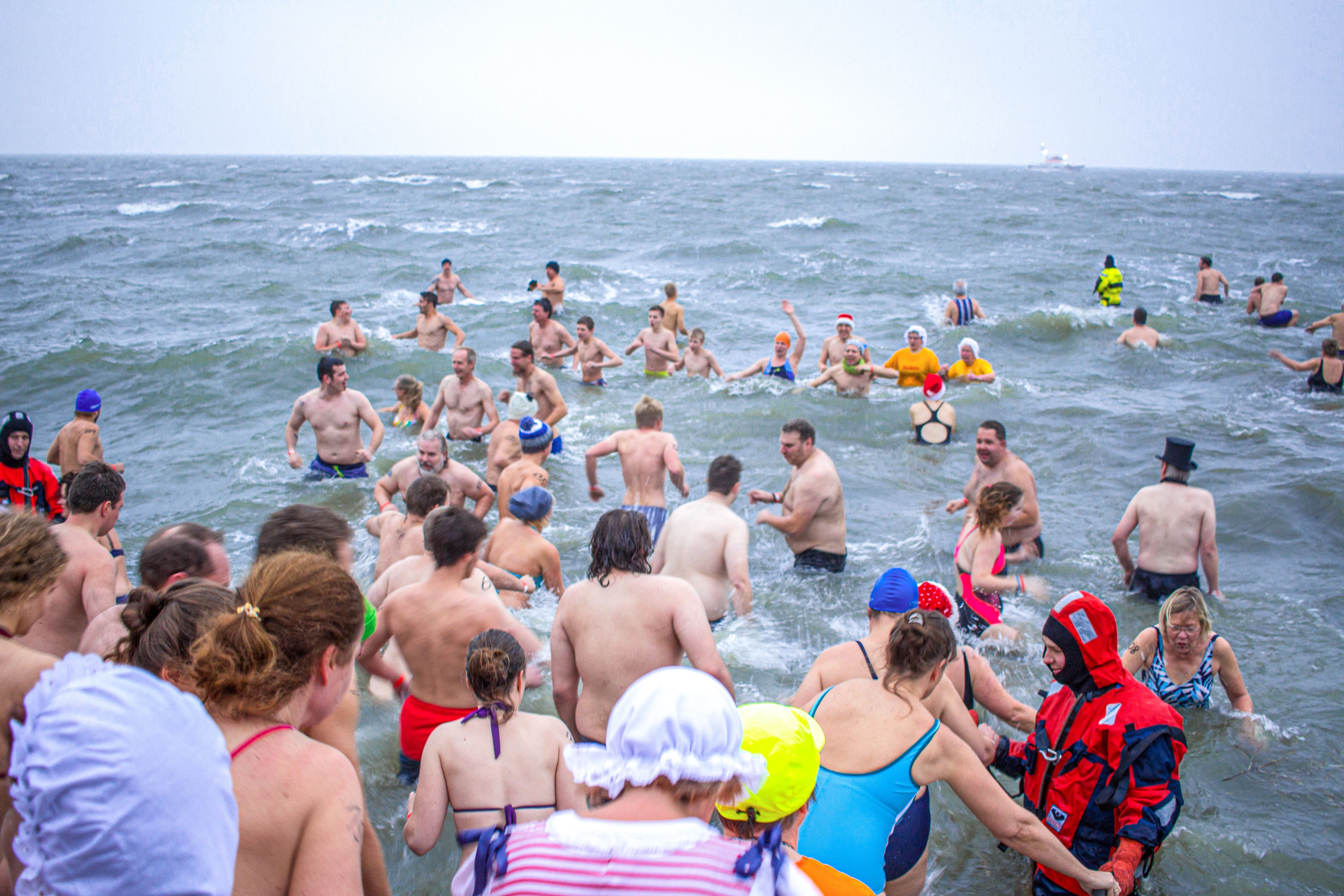 Menschen steigen ins Wasser beim Neujahrsanbaden