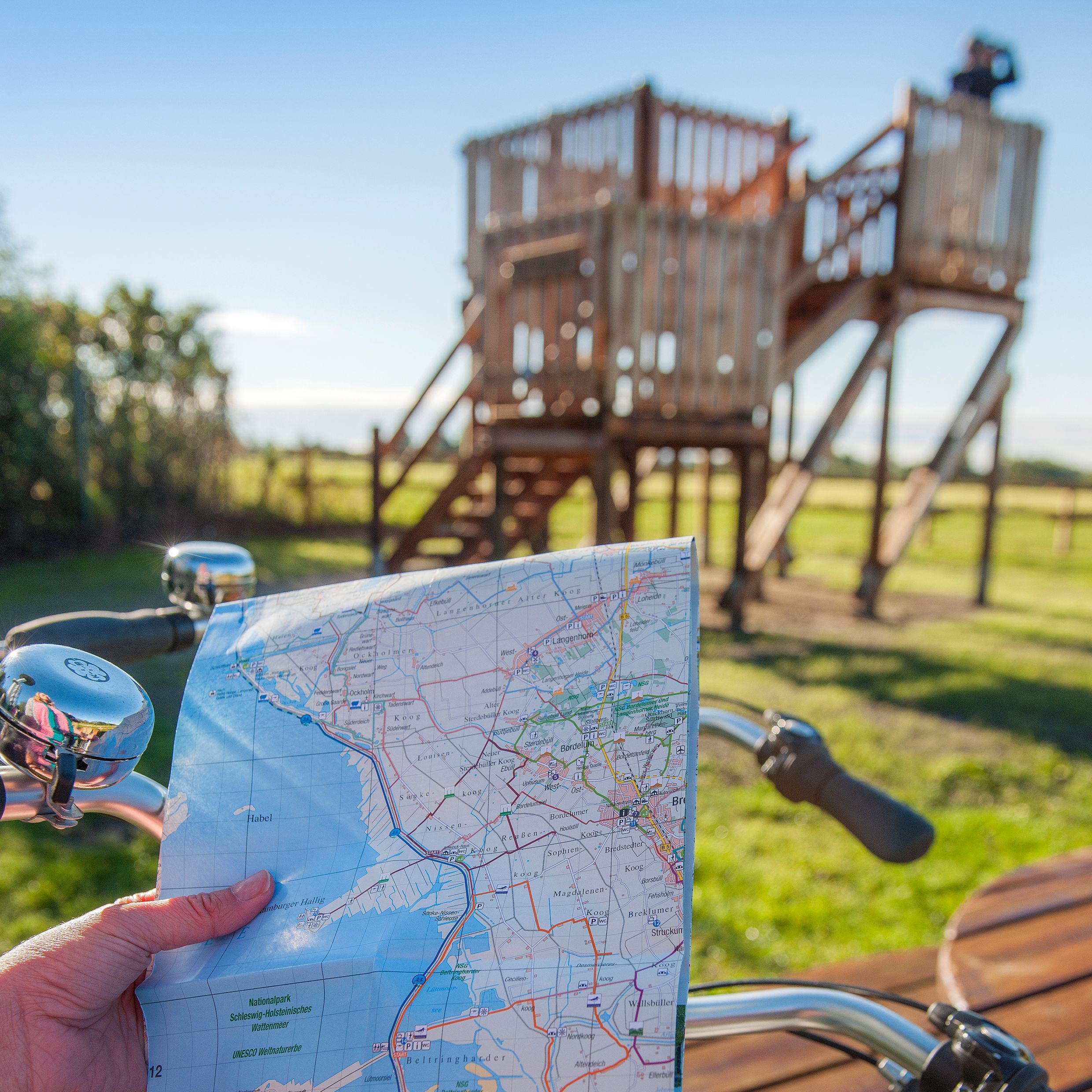 Ein Radfahrer schaut sich eine Radkarte der Nordsee vor dem Stollberg an