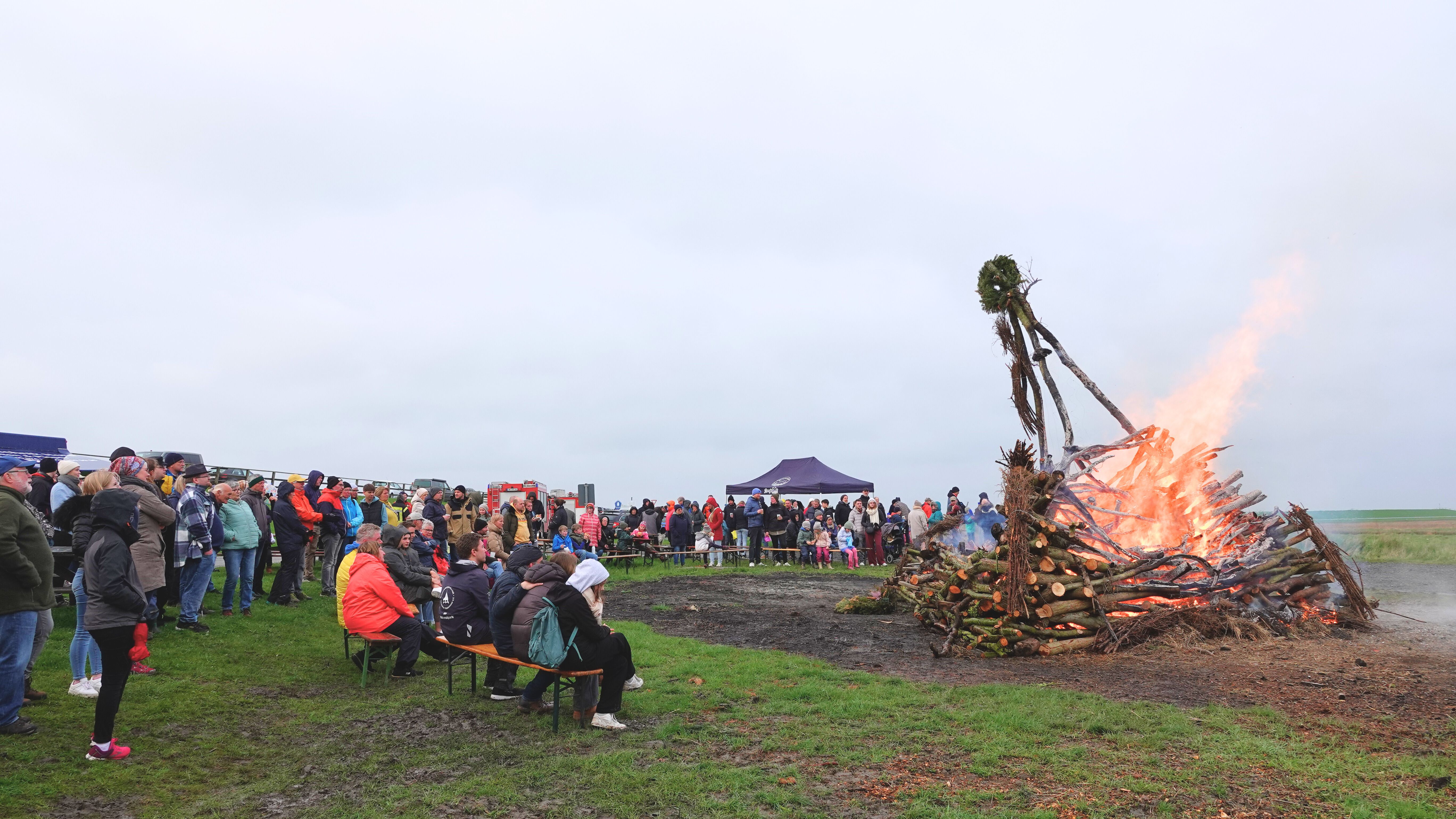 Viele Menschen schauen beim Osterfeuer auf Nordstrand am Außendeich zu.