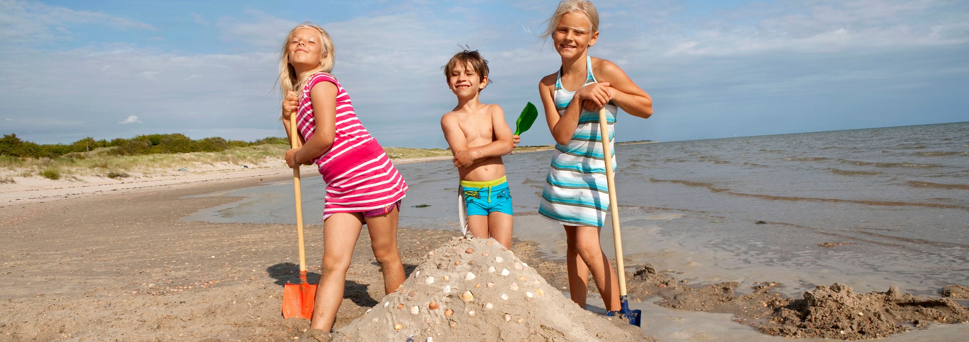Kinder Spielvergnügen am Strand während des Nordseeurlaubs