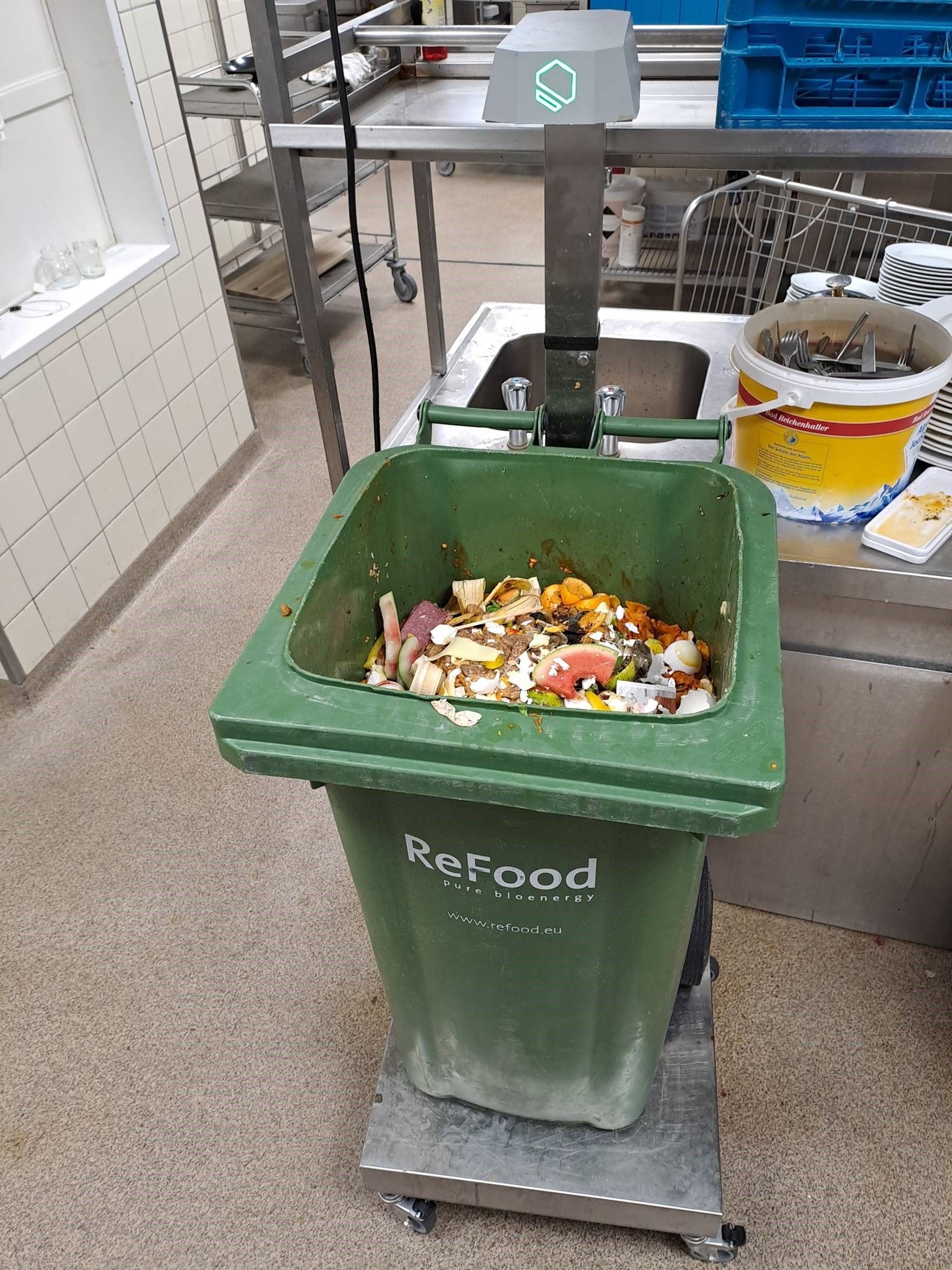 In einer Hotelküche steht eine offene Mülltonne mit Speiseabfällen