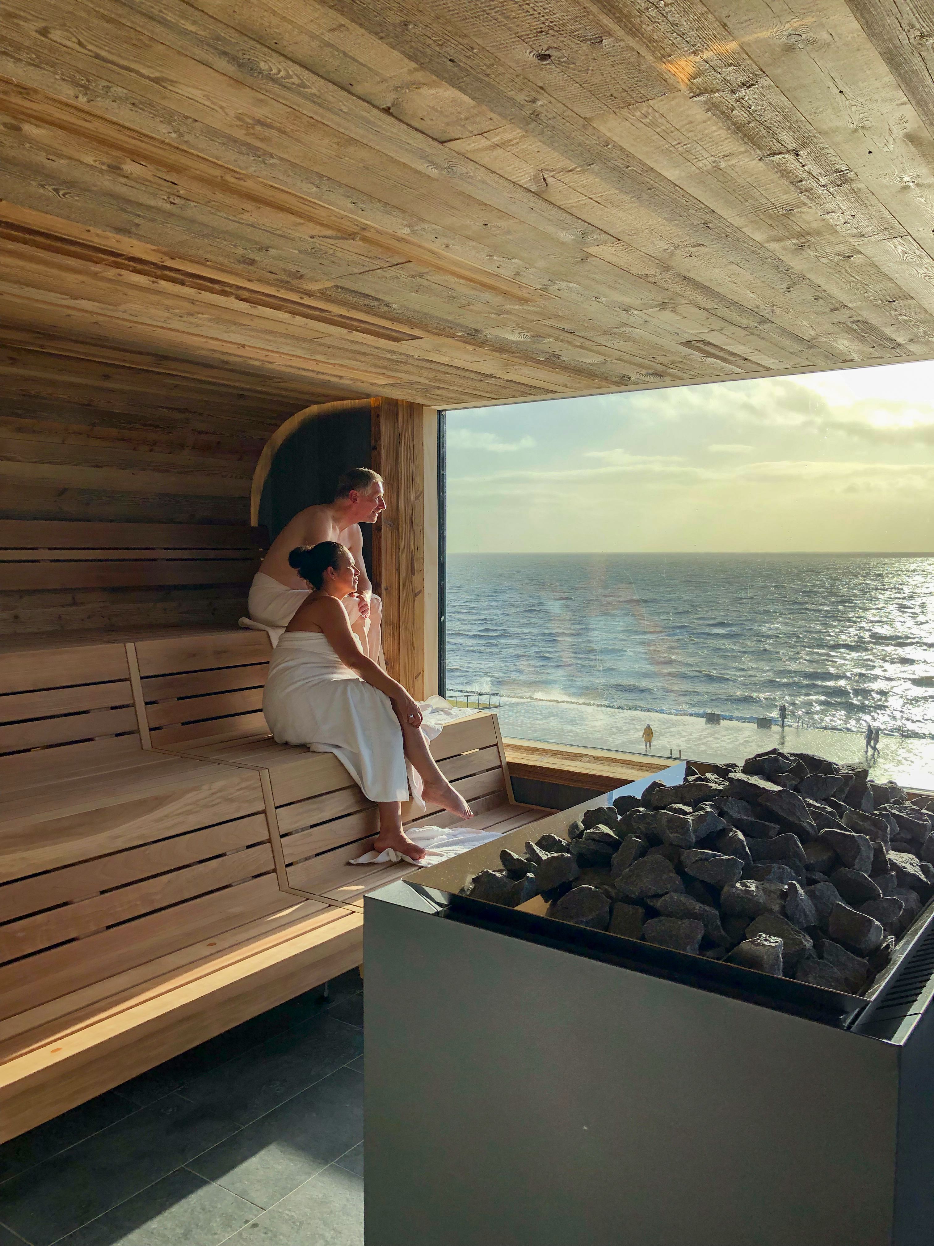 Eine Frau sitzt in der Sauna auf dem Dach der Meerzeit Büsum