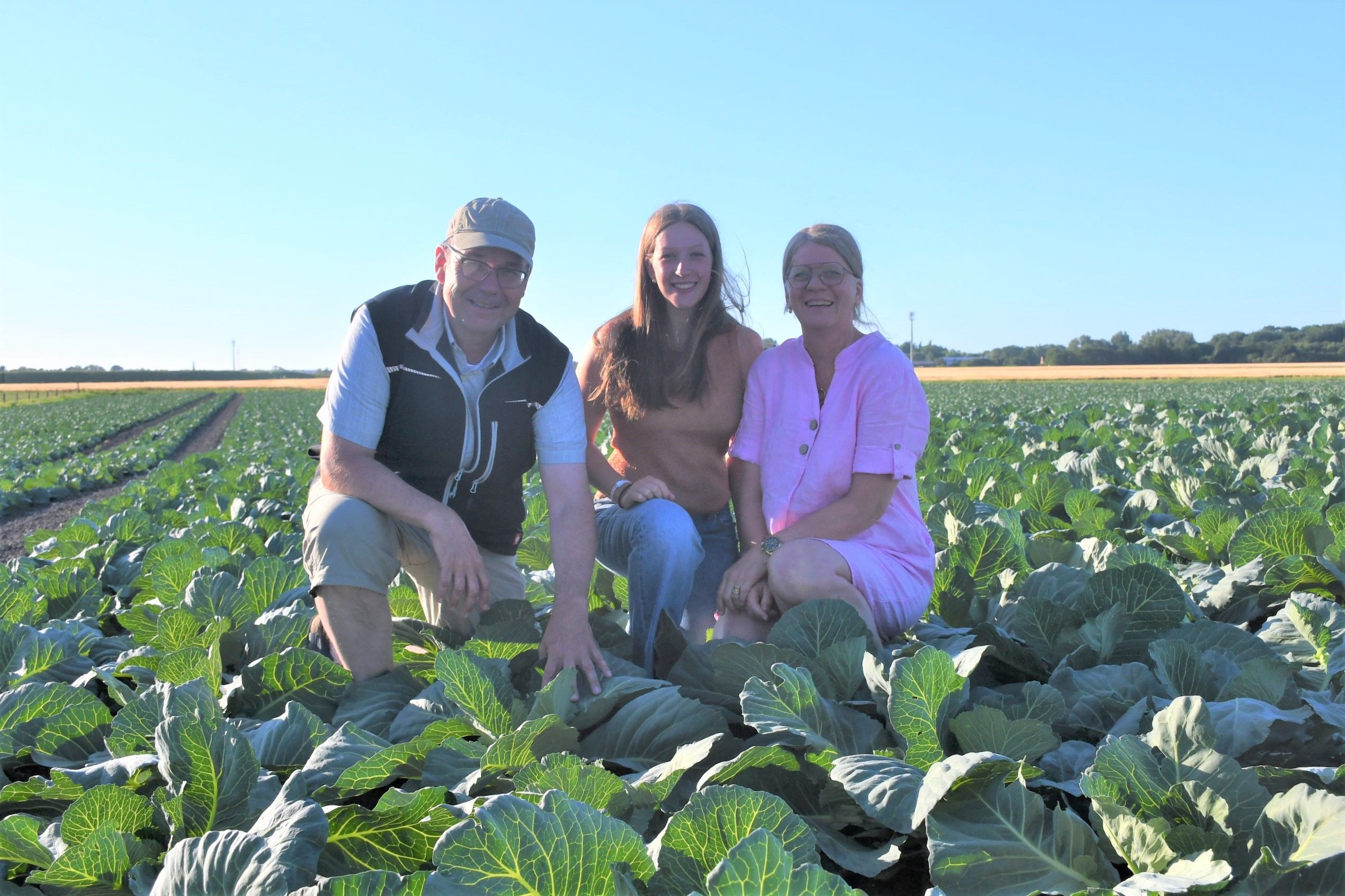 Auf dem Kohlfeld für das Anschnittsfest in Zennhusen knieen von links Thies Hagge-Kern sowie Lenna und Andrea Hagge. Foto: Kreis Dithmarschen