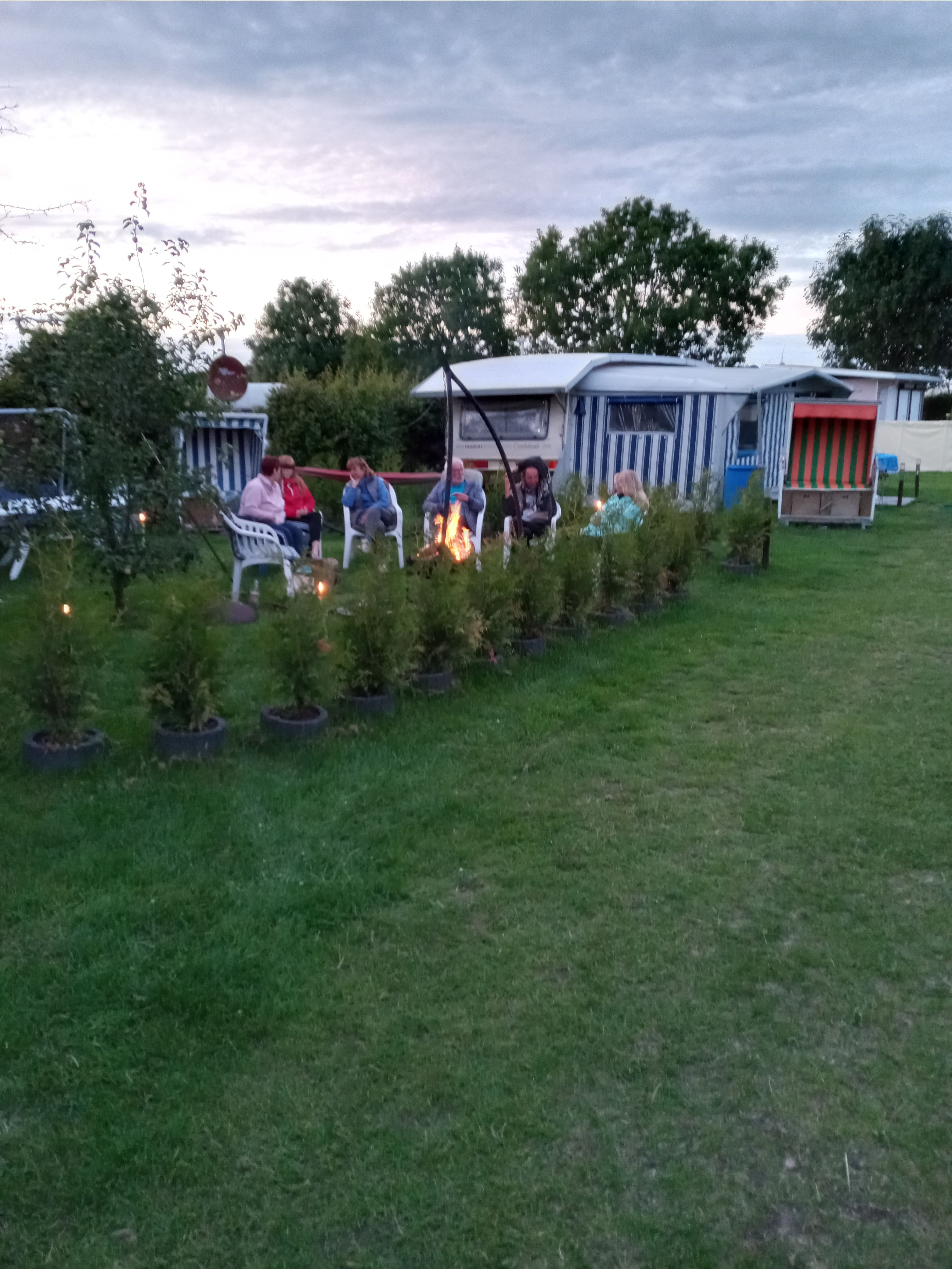 Eine Familie sitzt vor ihrem Zelt auf dem Campingplatz Seeluft