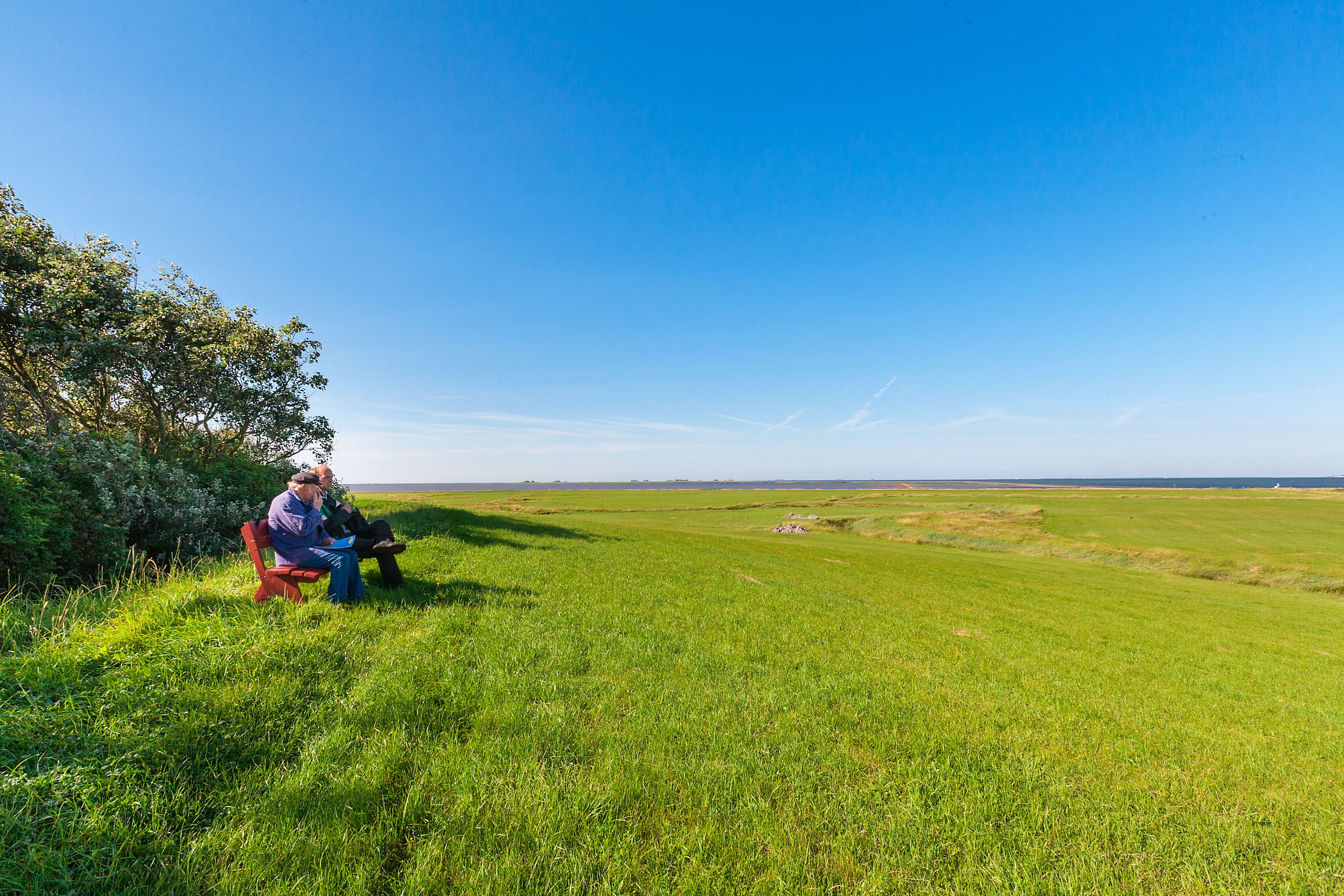 Zwei Personen entspannen auf einer Bank auf Oland