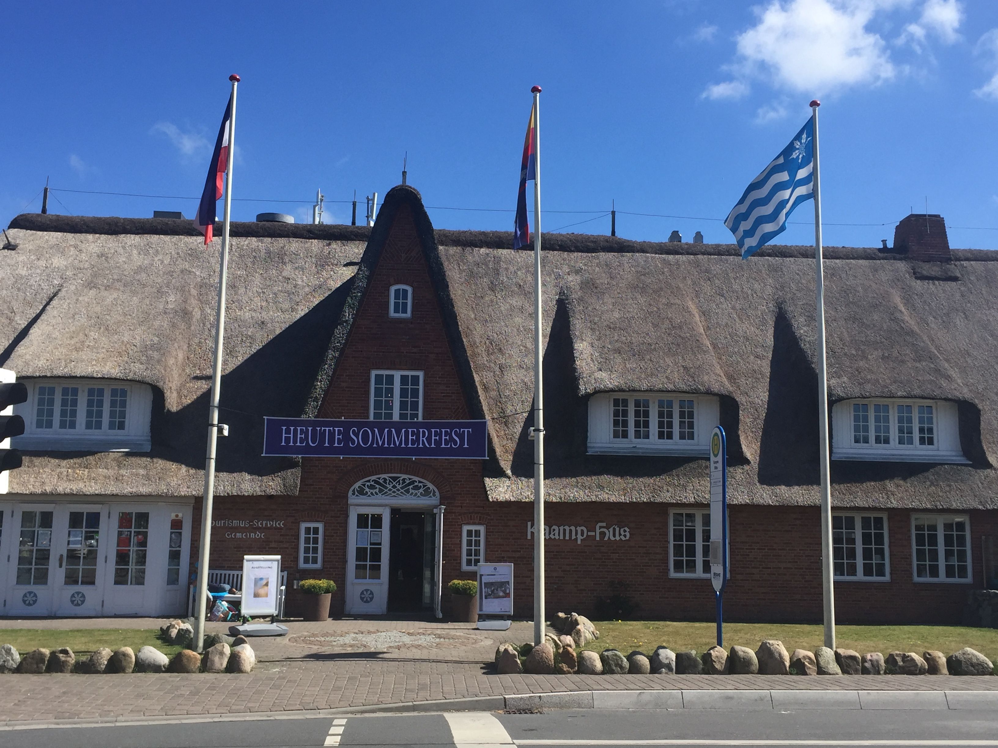 Außenansicht des Gebäudes des Tourismus-Service Kampen, vor dem ein Banner zuM Sommerfest hängt