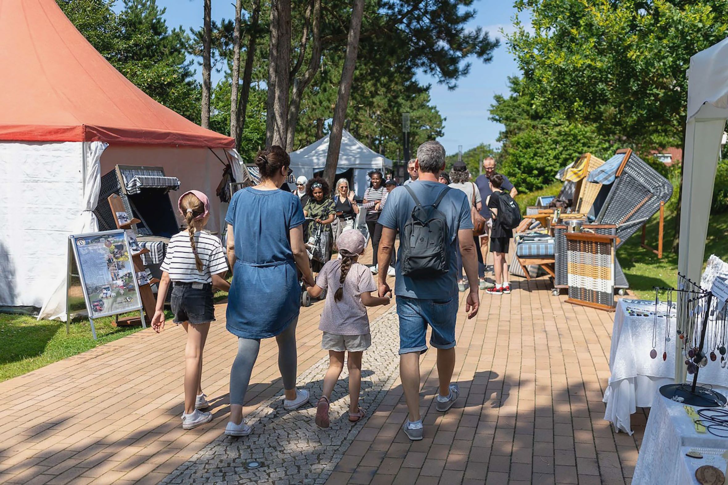 Besucher gehen durch das Festivalgelände.