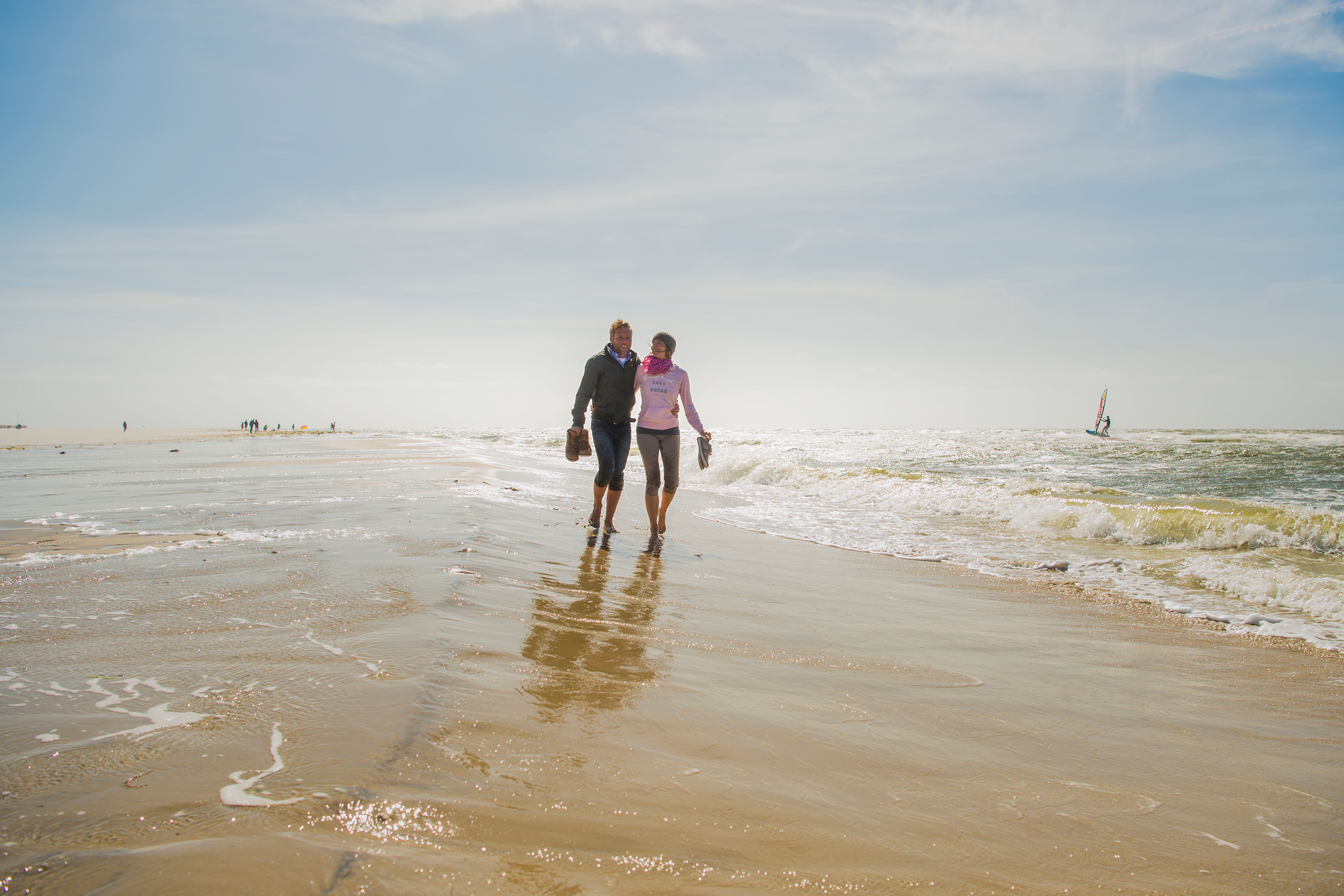 Paar spaziert in ihrem Strandurlaub gemeinsam am Strand.  
