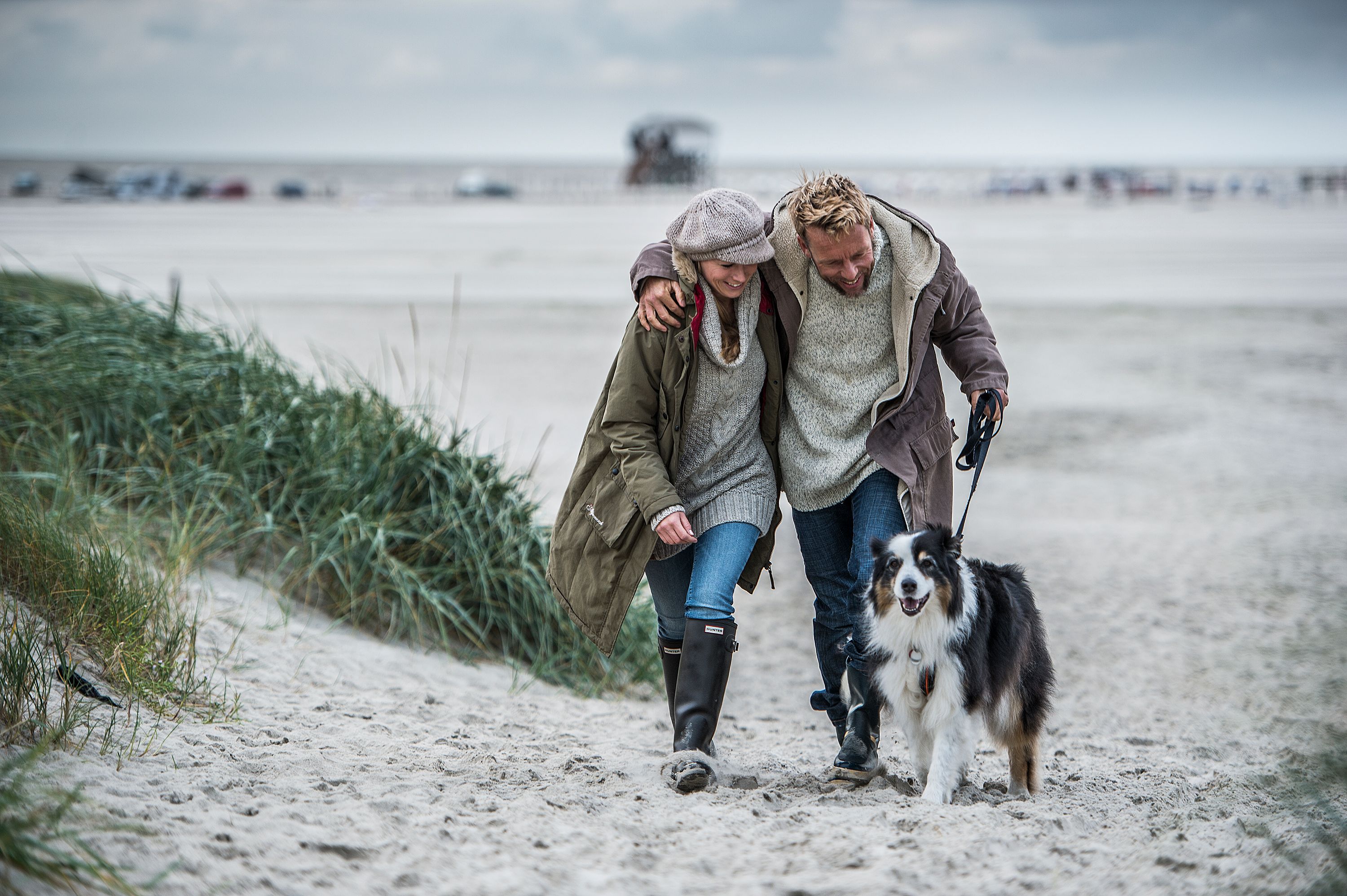 Paar mit Hund im Herbst am Strand von St. Peter-Ording