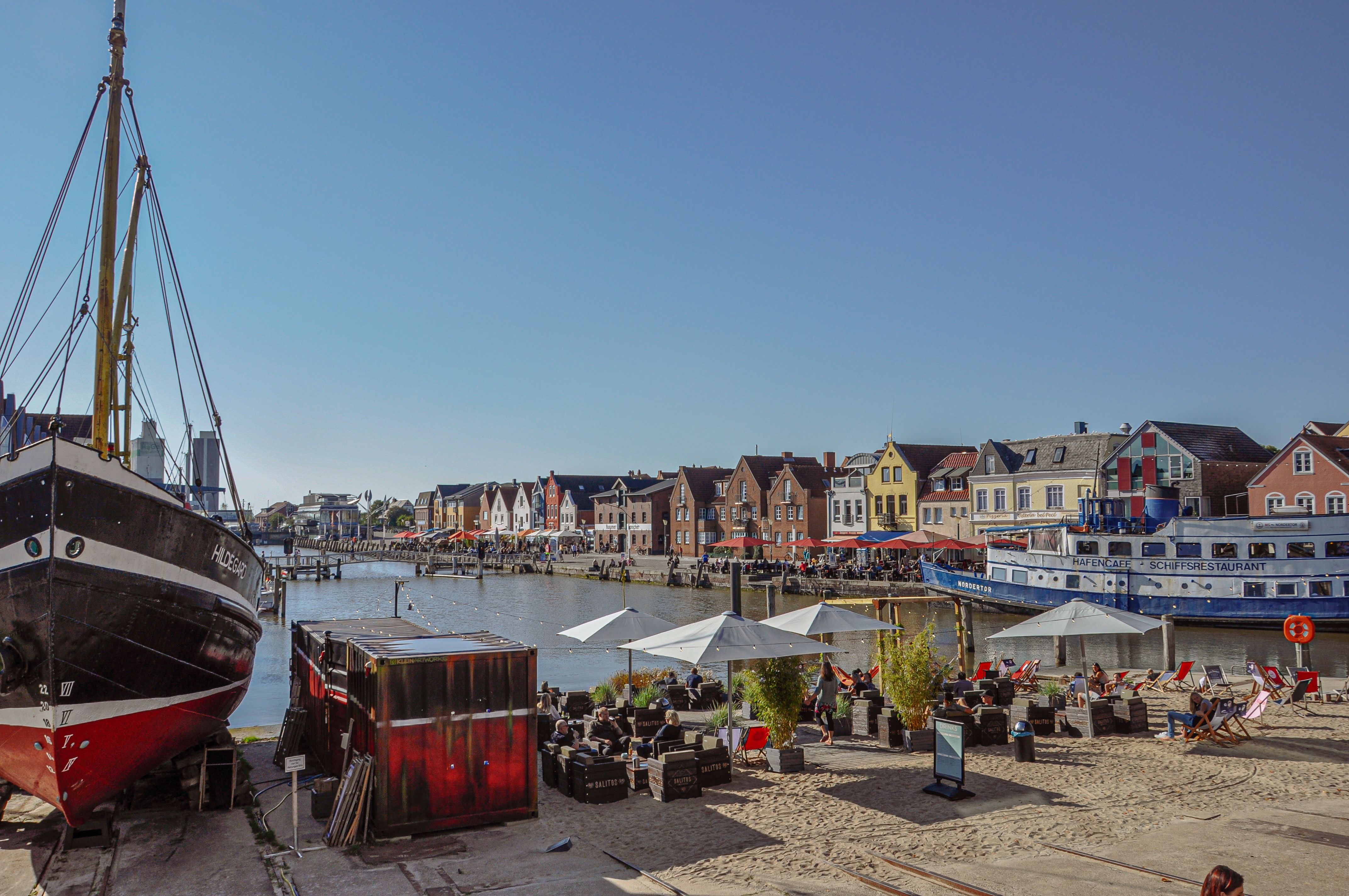 Die Beachbar Husum im Binnenhafen von Husum, im Vordergrund ist ein altes Schiff zu sehen