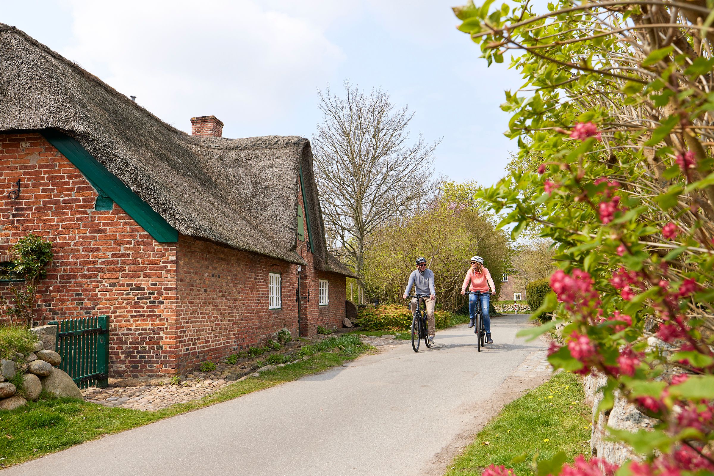 Zwei Radfahrende erkunden die Dörfer auf Sylt.